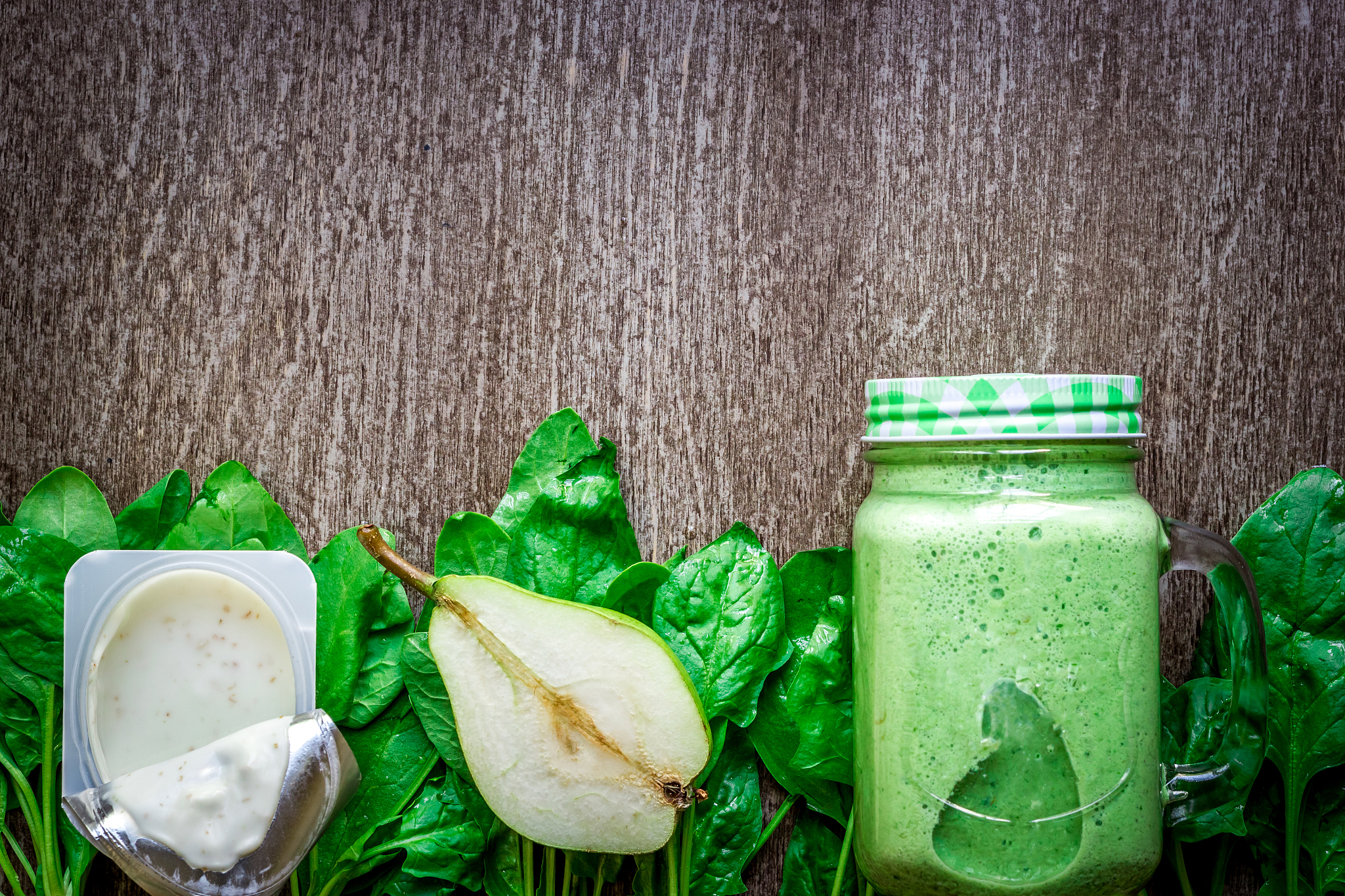 glass of spinach juice on wooden background