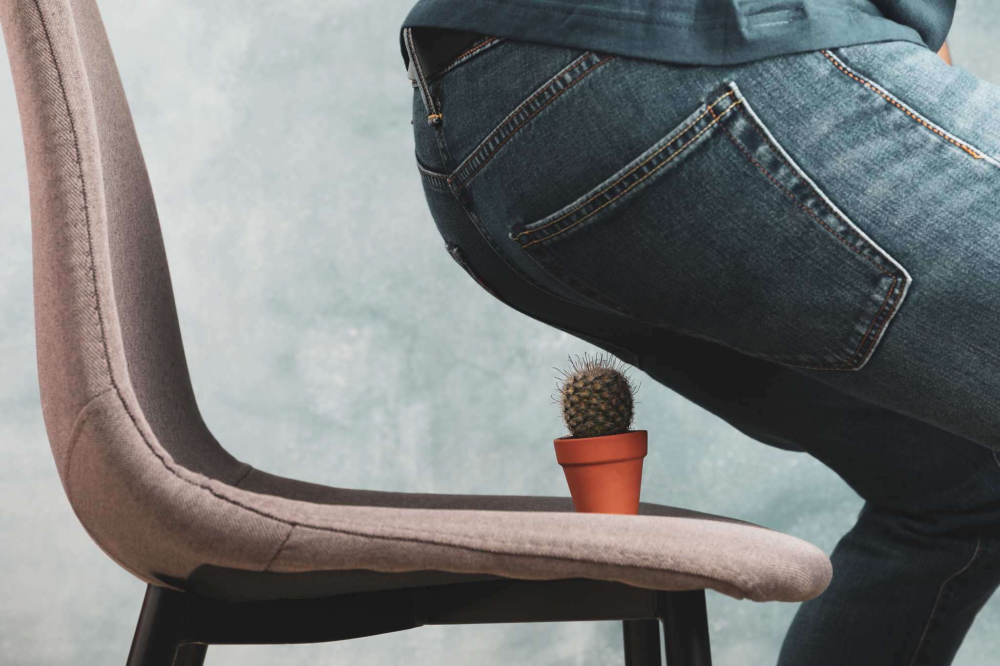 man sit on a chair with cactus. hemorrhoids