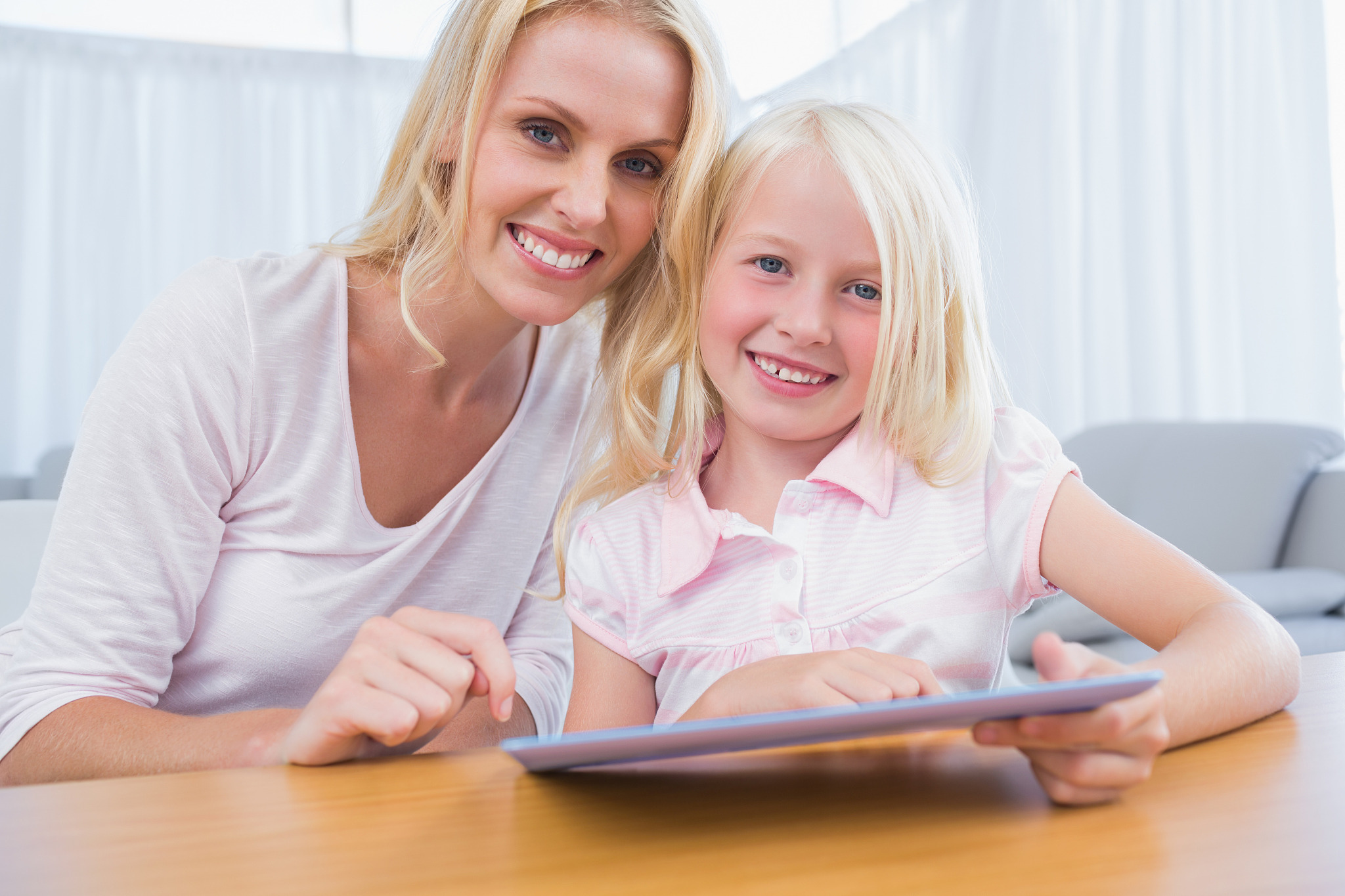 mother and daughter using tablet pc together in the living room
