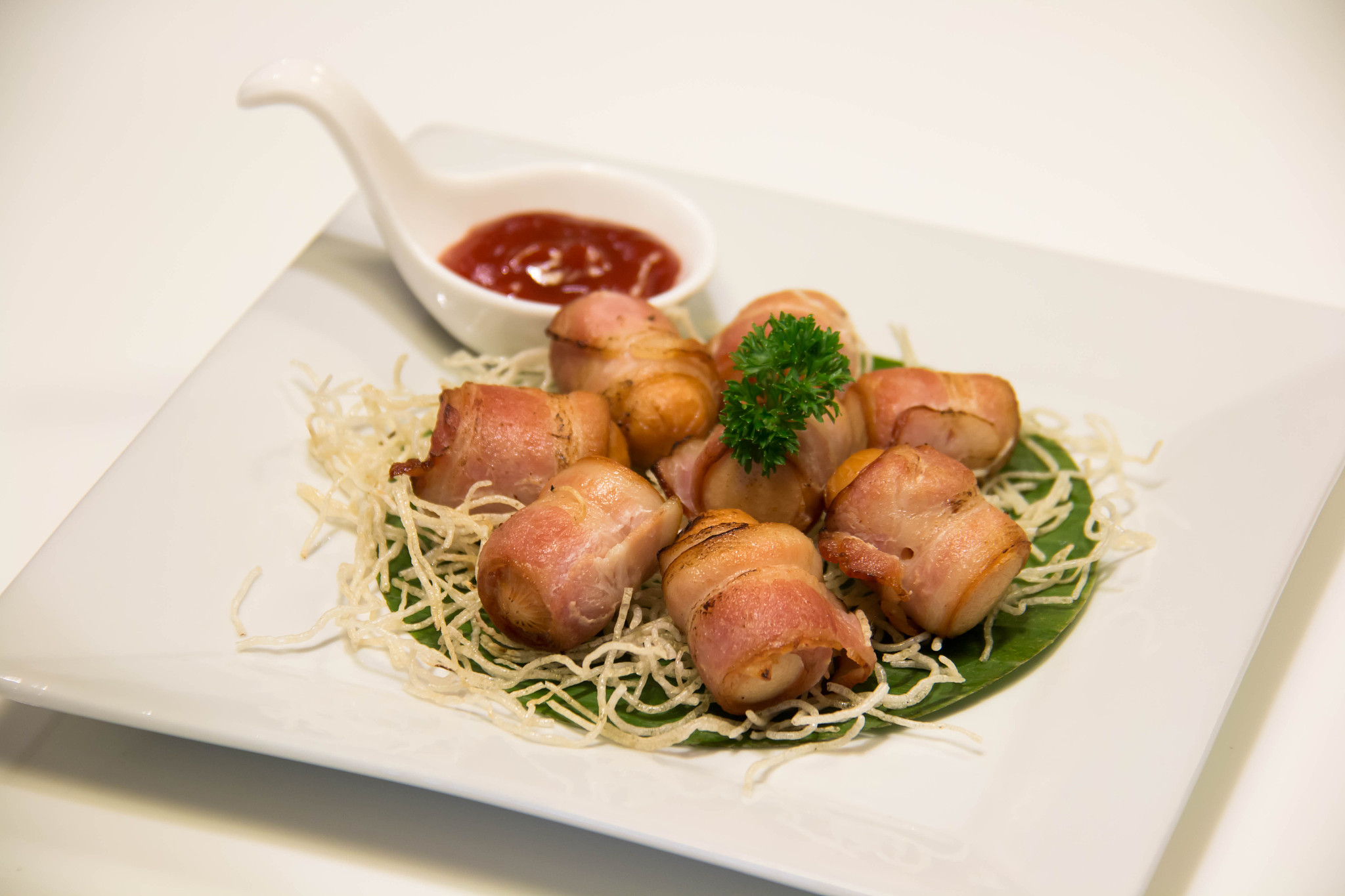 deep fried bacon wrapped sausage with sauce