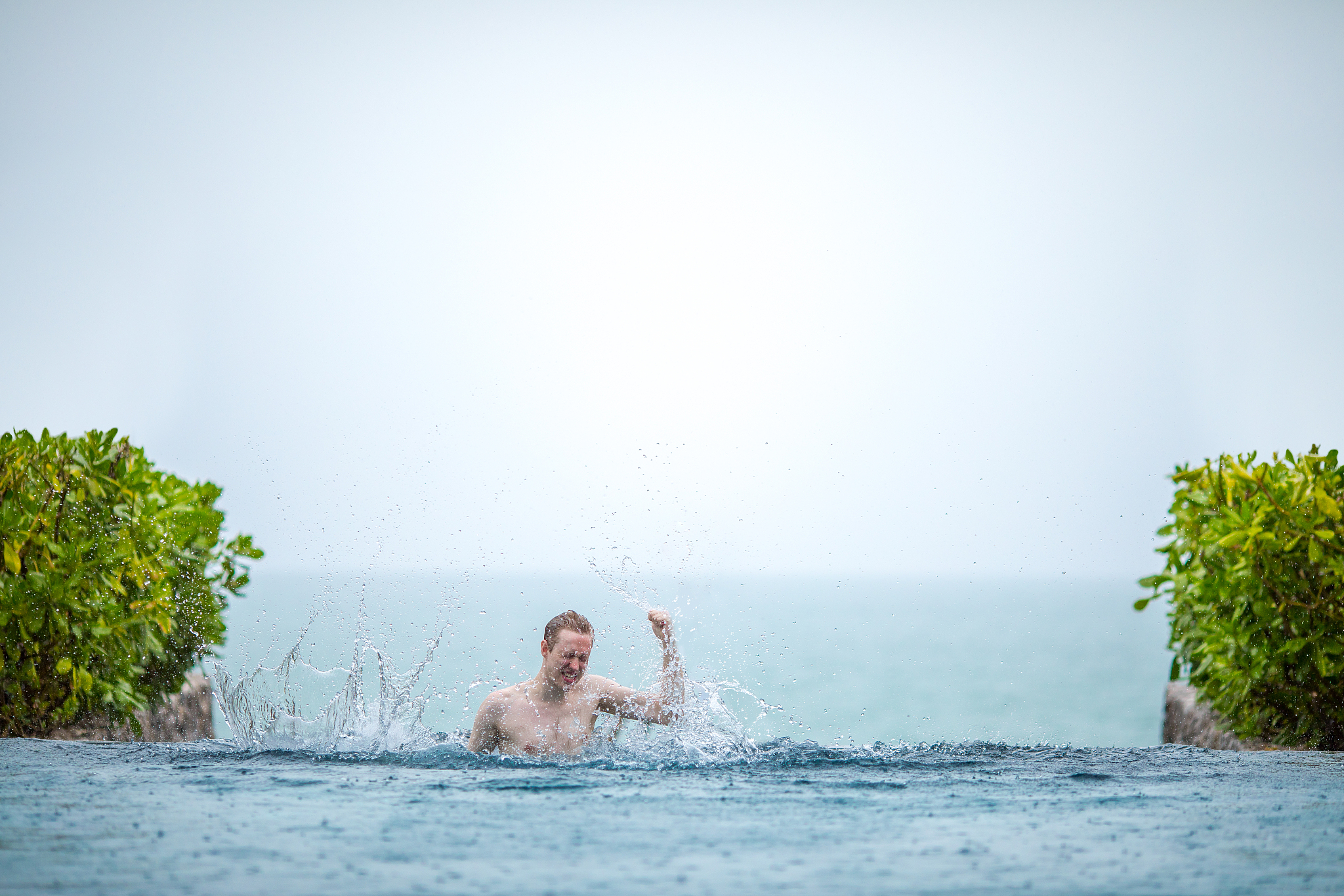 young man basking in the infinity pool