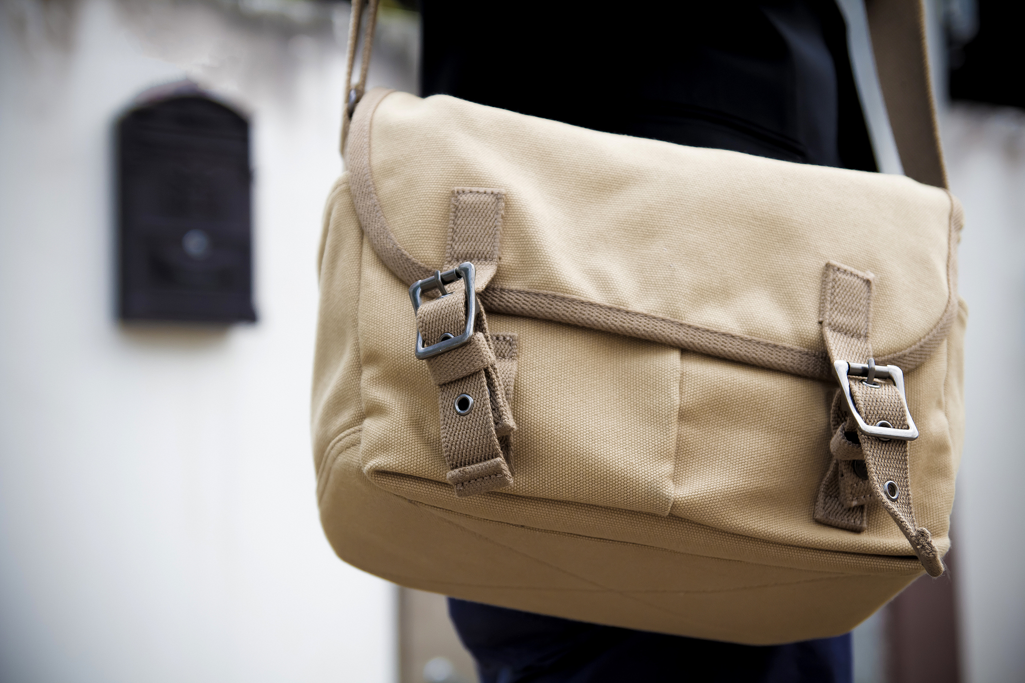 brown shoulder bag of messenger standing in front of the mailbox