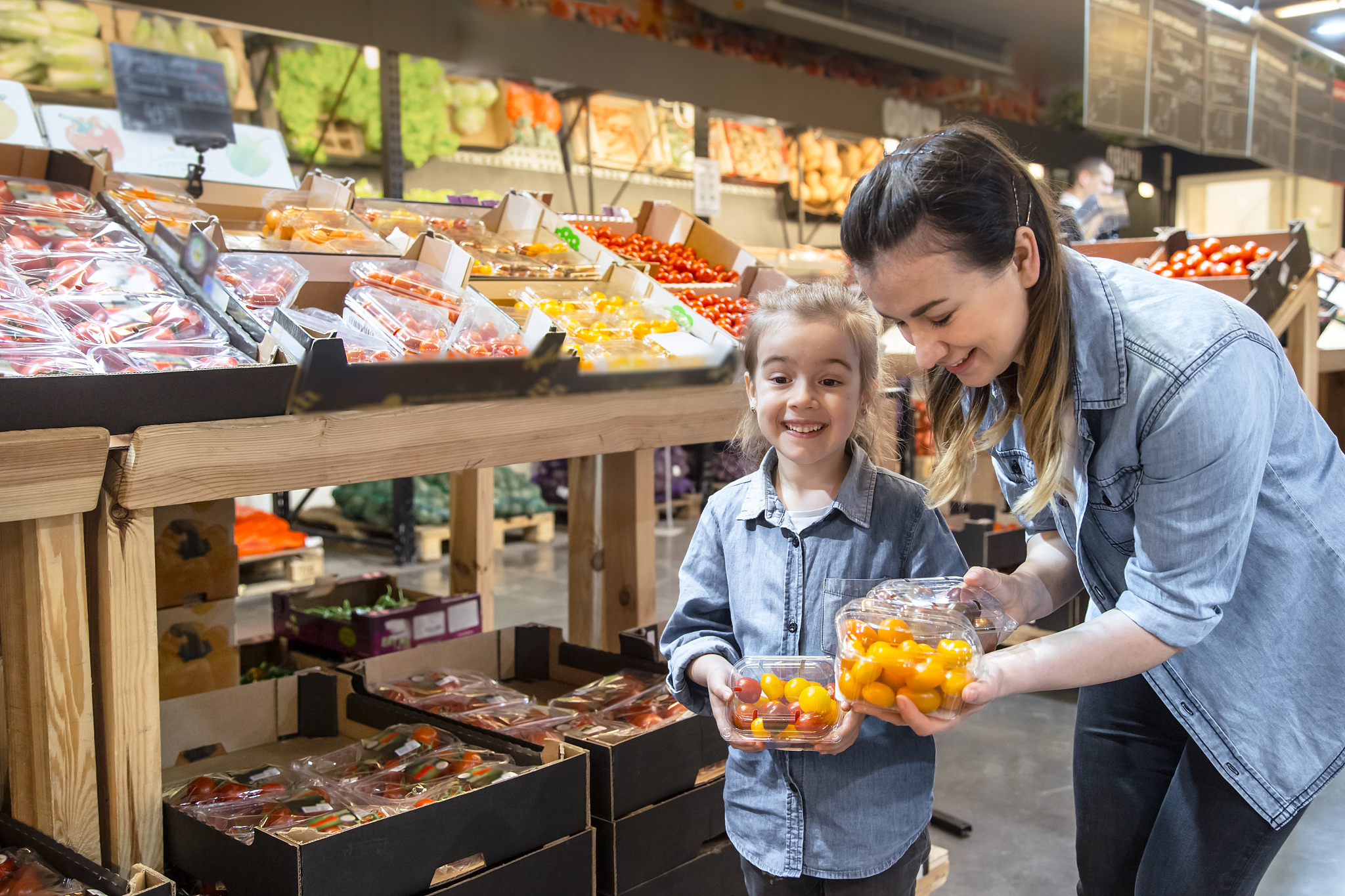 cheerful smiling young woman with little daughter buying globe t