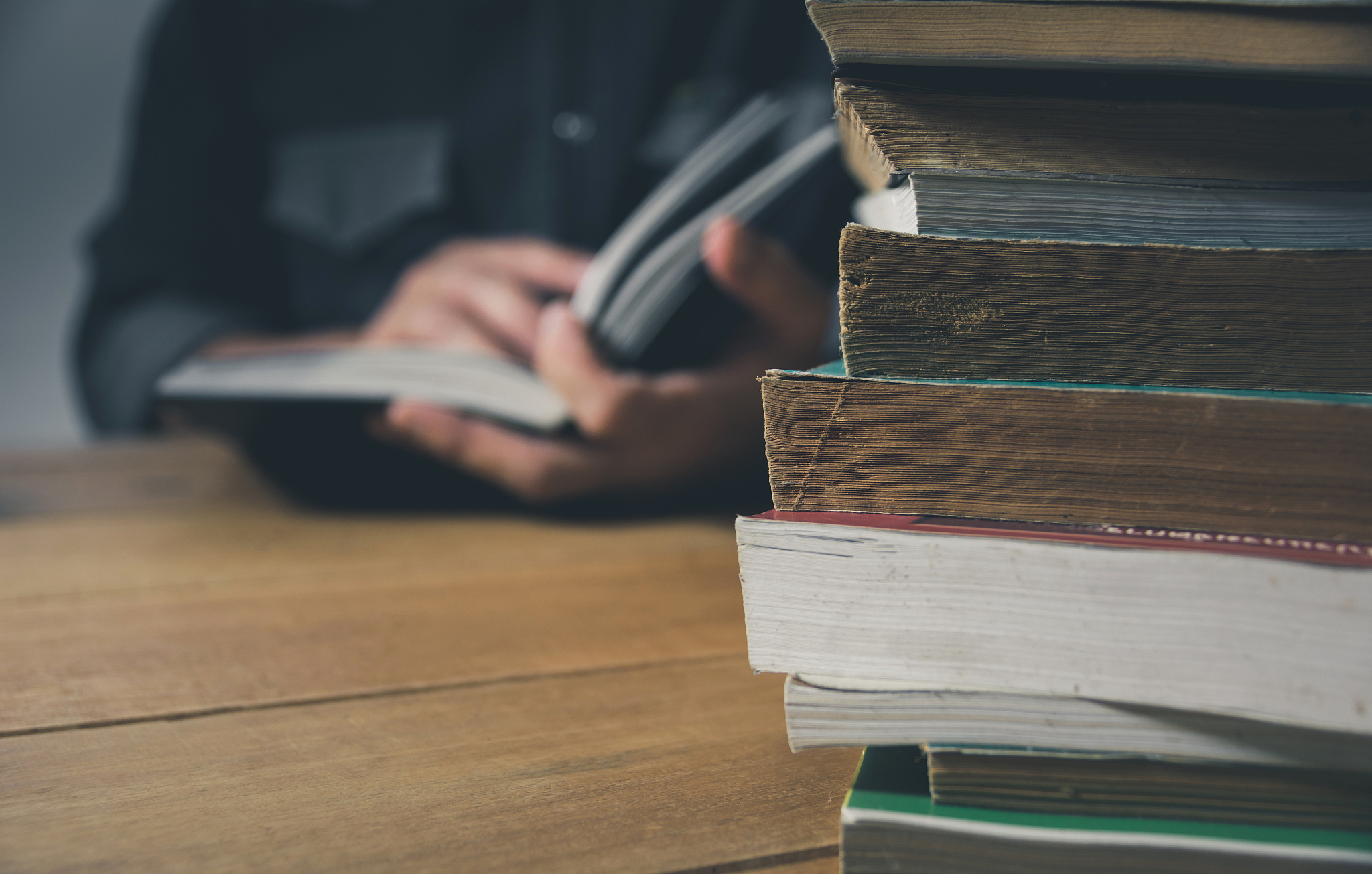 midsection of man reading book at table