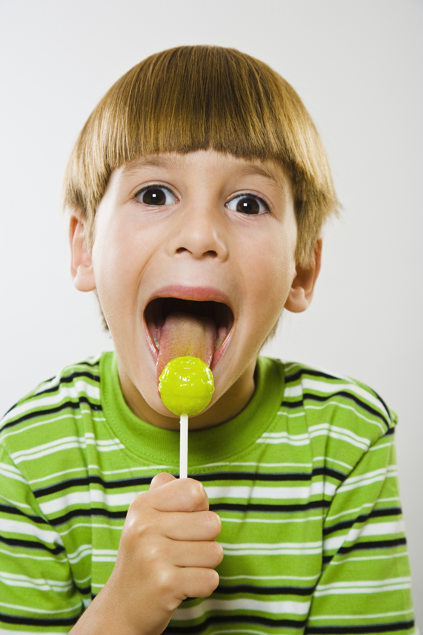 young boy enjoying green lollipop
