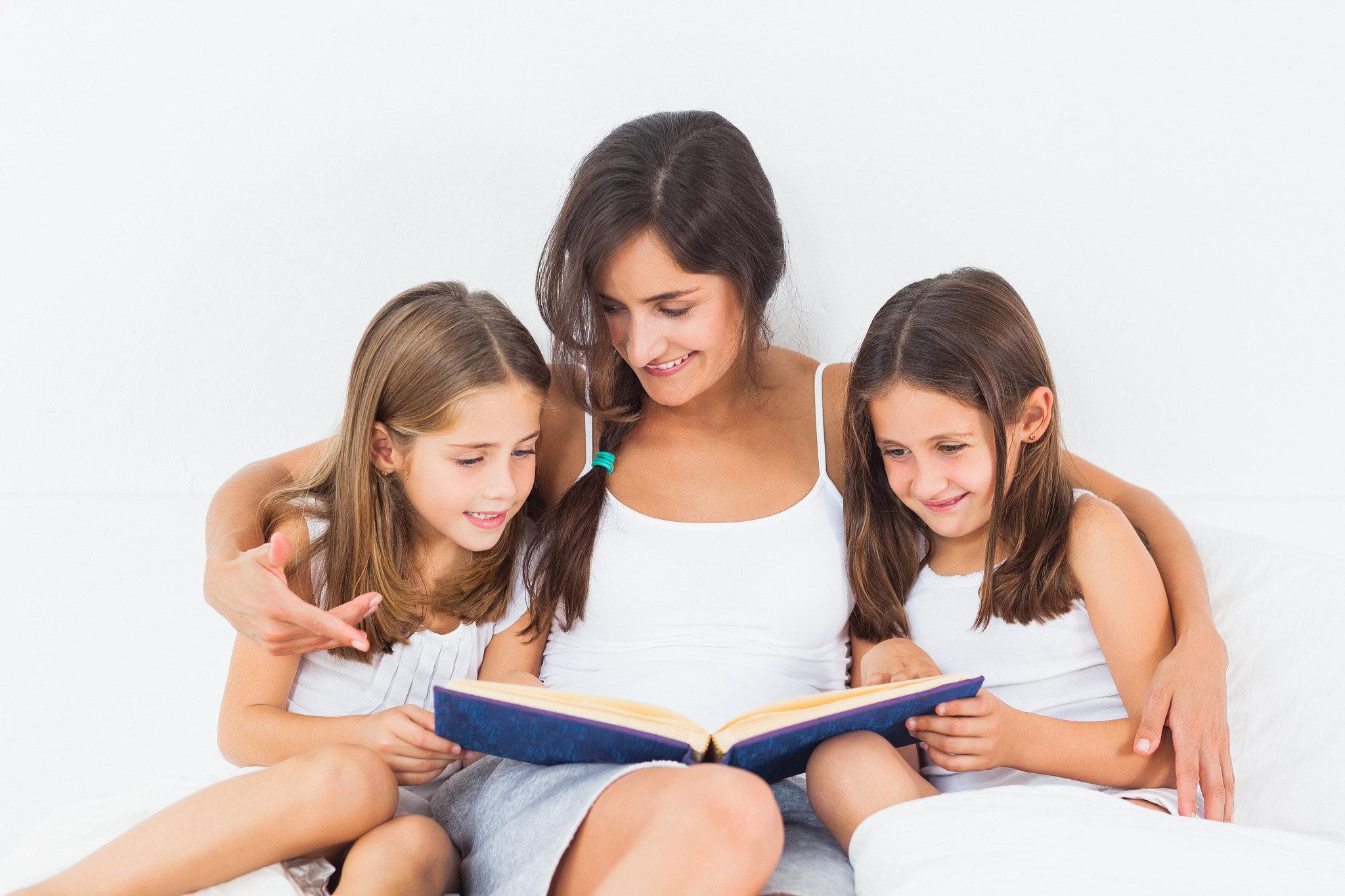 mother and her children looking at a photo album in the bedroom