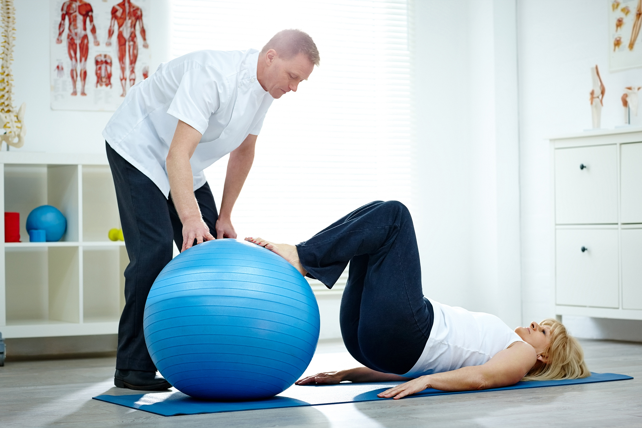 patient doing pilates exercises with physical therapists