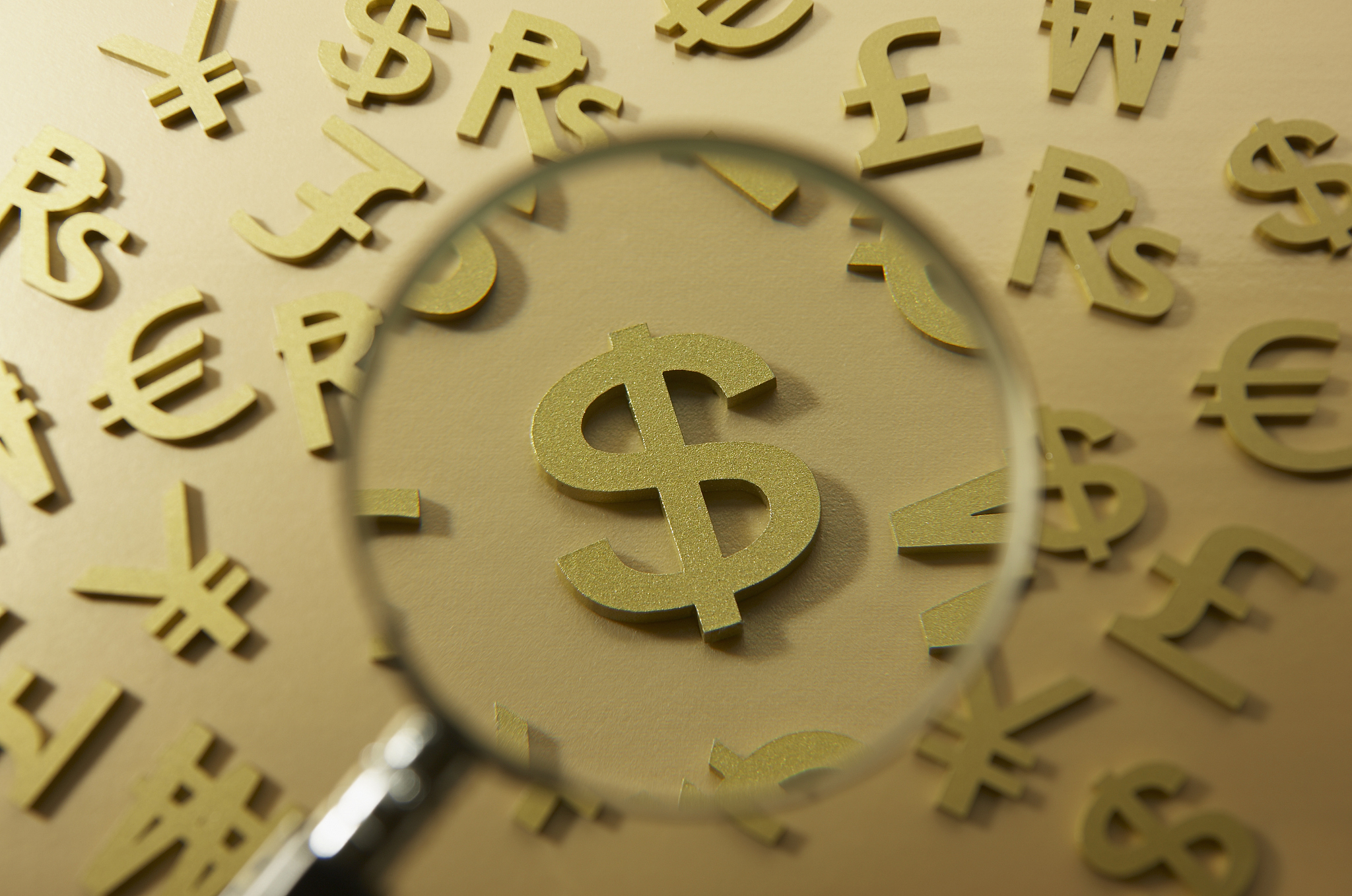 magnifying glass on dollar symbol.