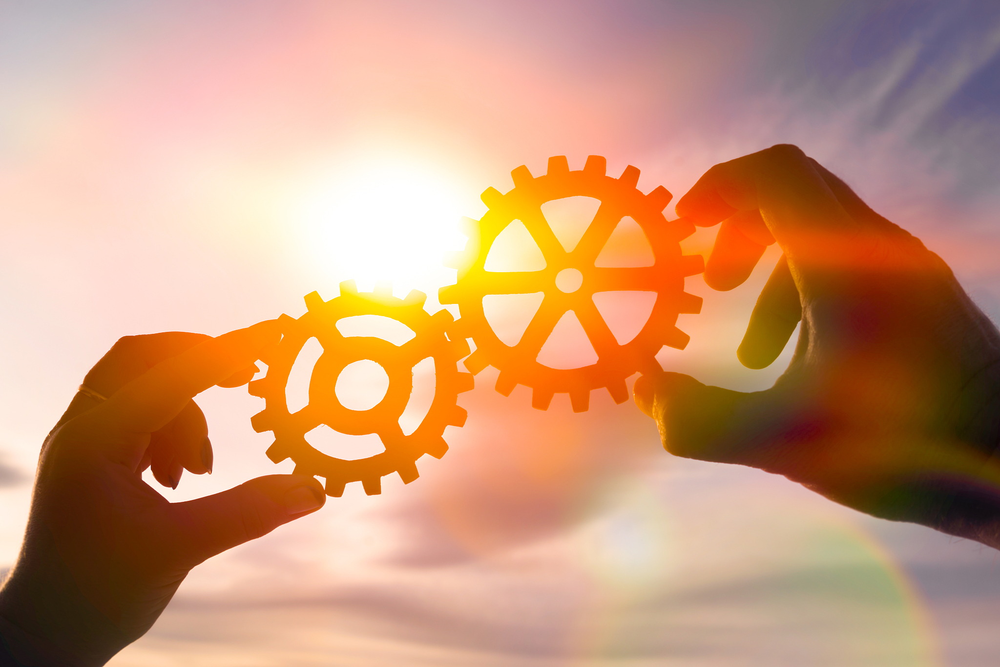 two hands of businessmen collect the gear from the gears of the 