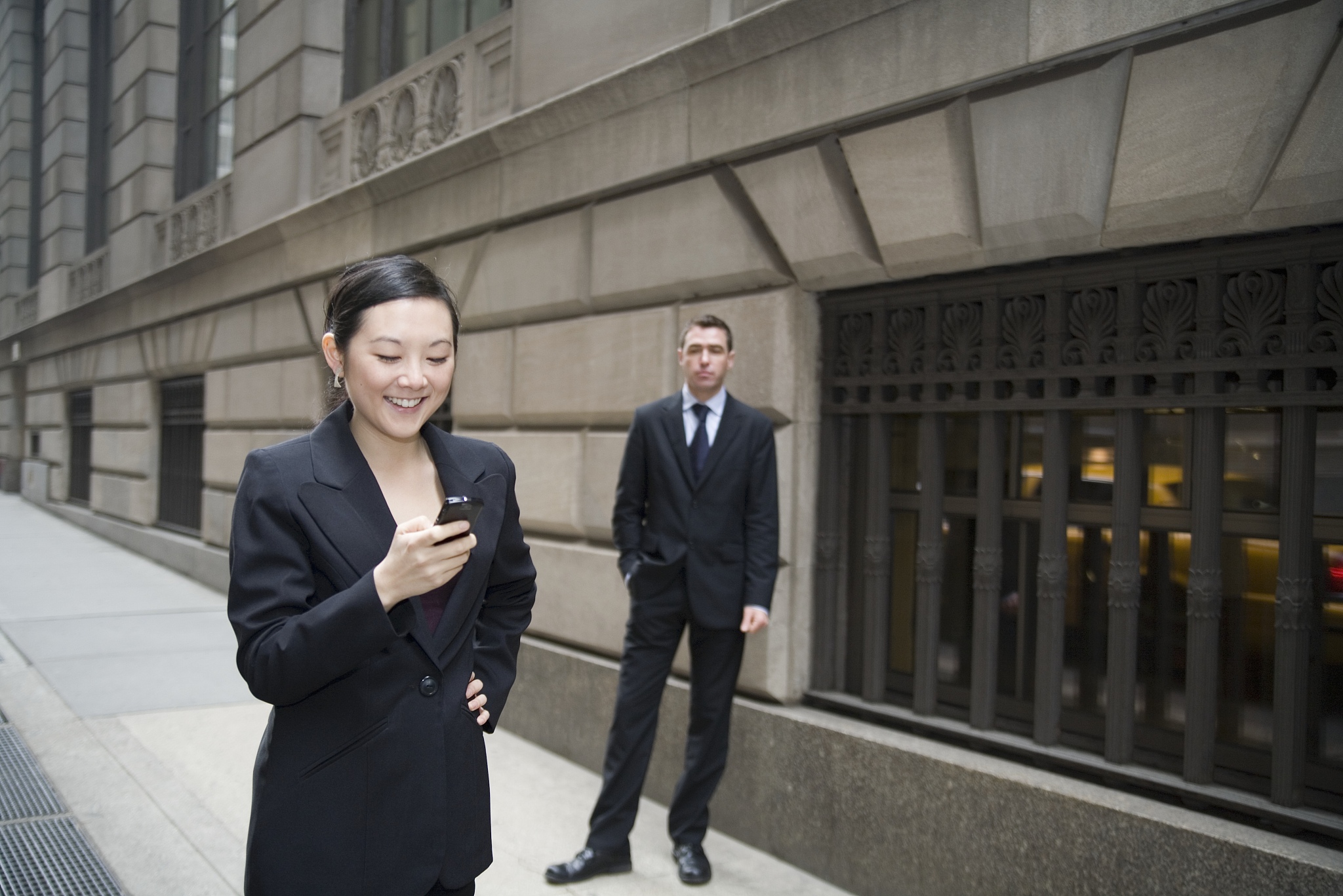 businesswoman using mobile phone and businessman waiting in the 