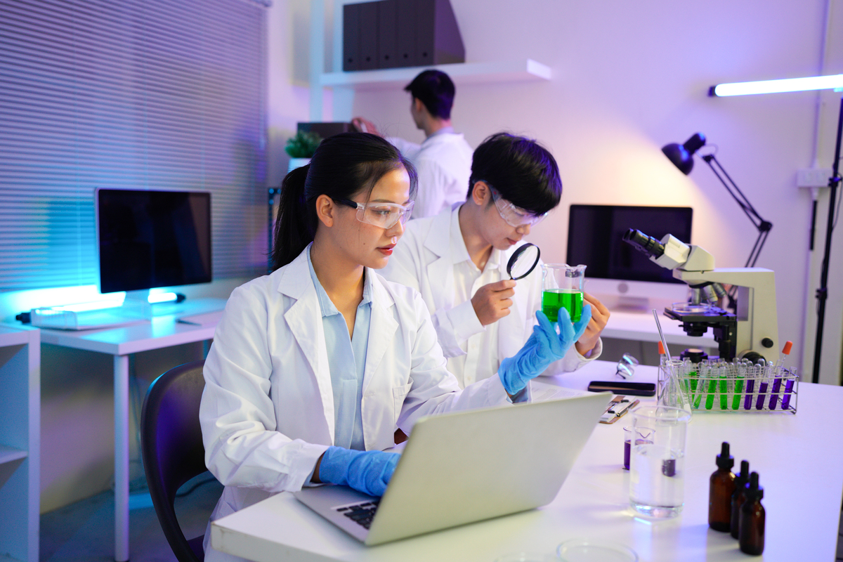 身着实验服的年轻科学家们在高科技实验室里协作,一位