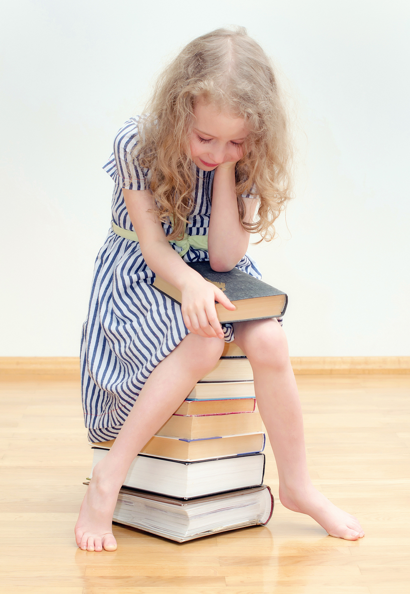 little girl with many books at home.