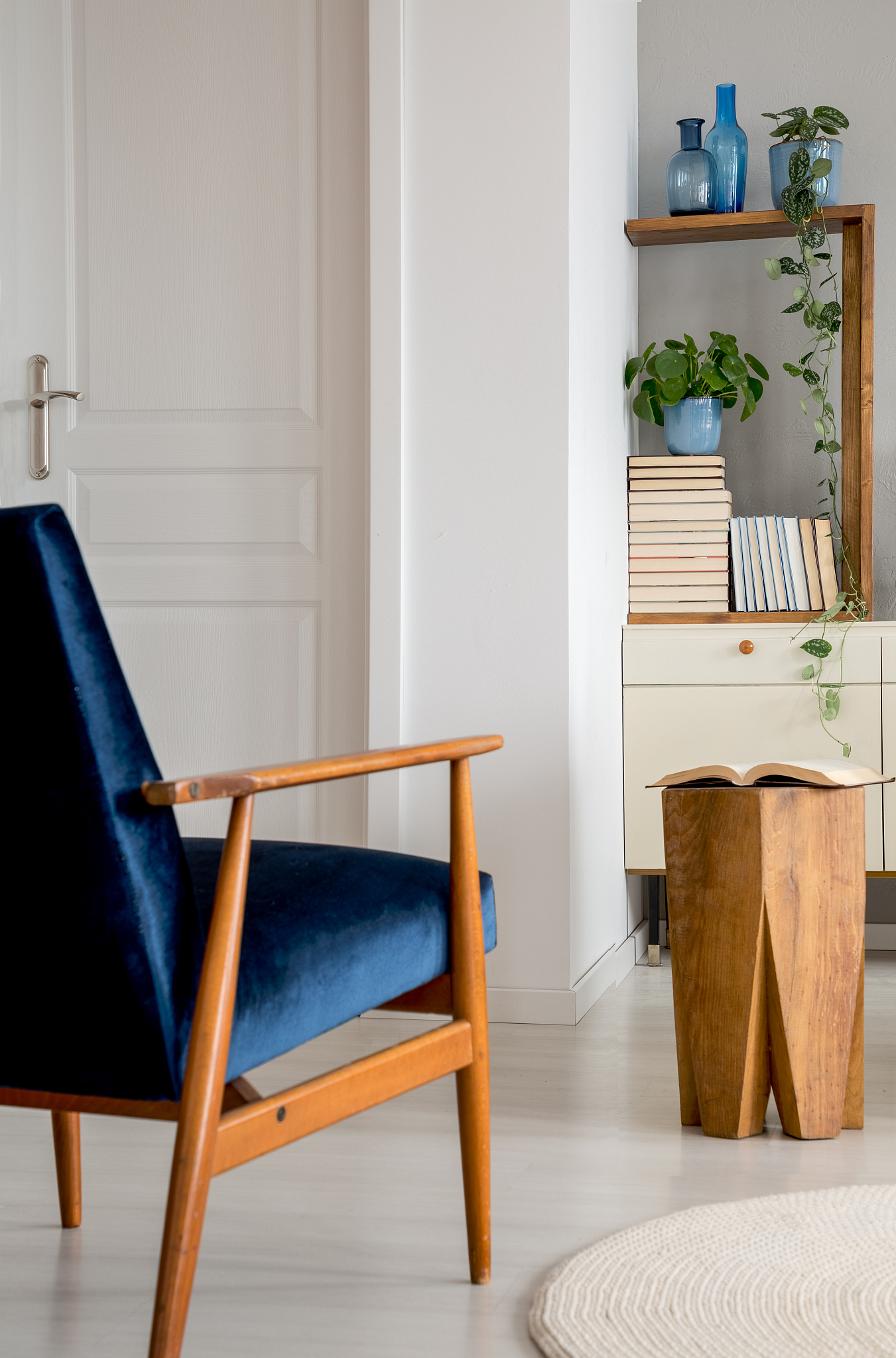 navy blue wooden armchair in white living room interior with sto