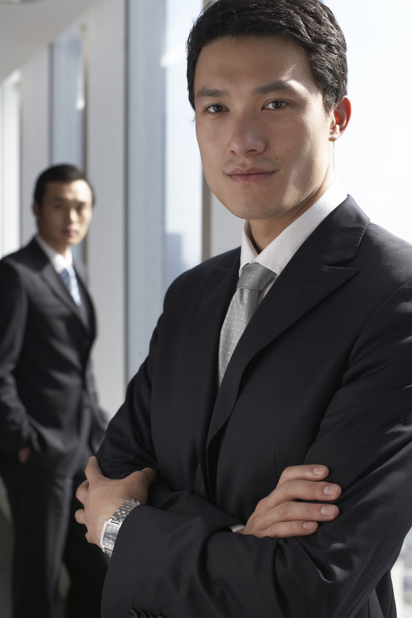 businessmen standing by window, focus on foreground