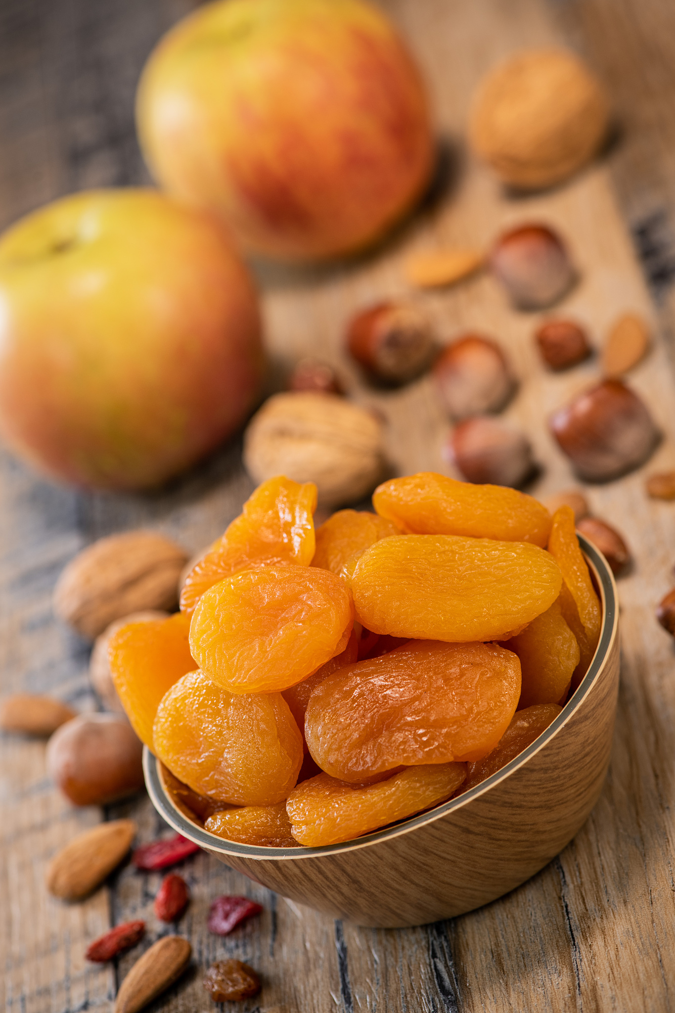 apricots, dried fruit and apple composition on wood background
