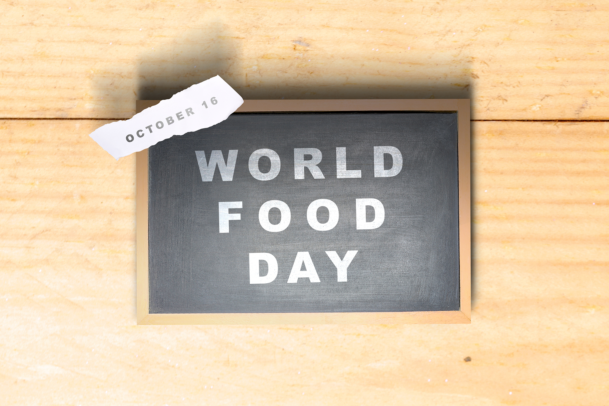 chalkboard with world food day text and ripped paper with the da