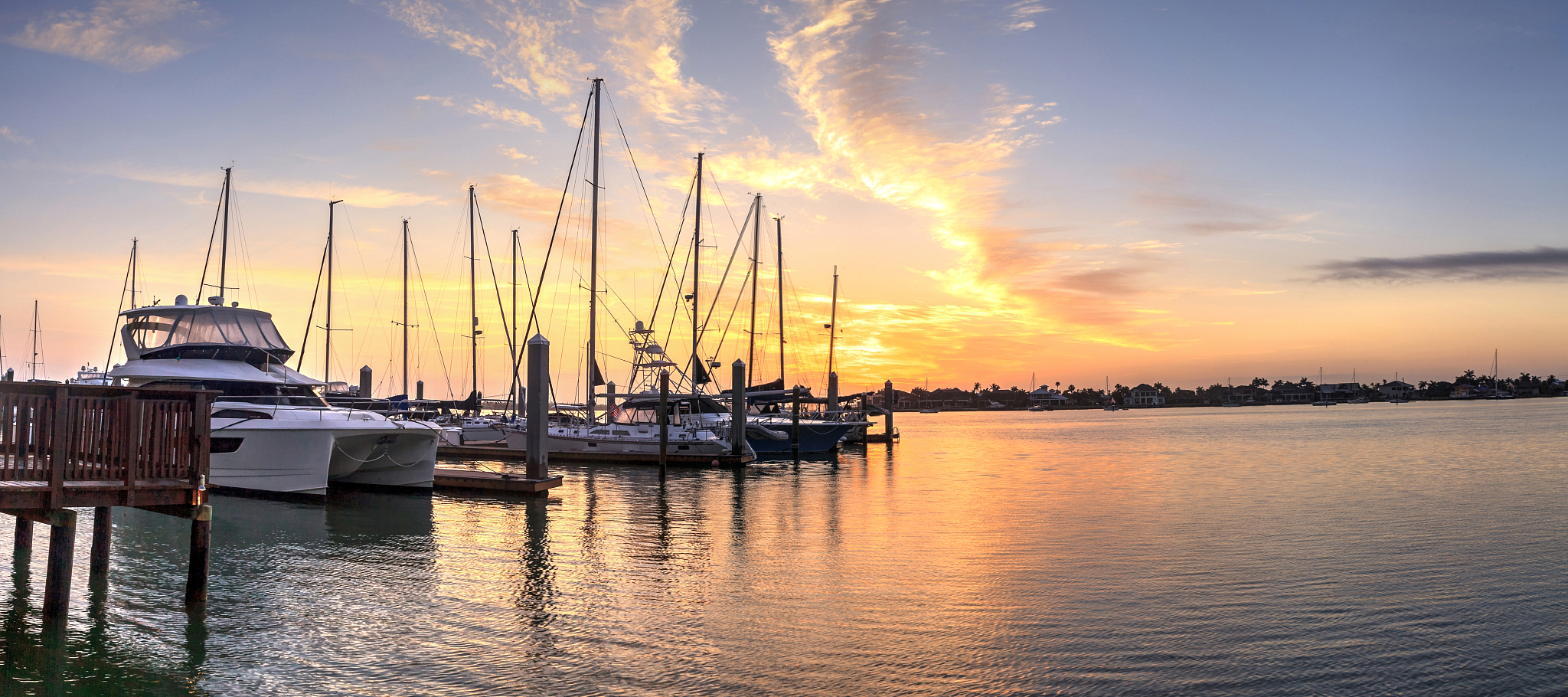 break of dawn sunrise over boats and sailboats at factory bay ma