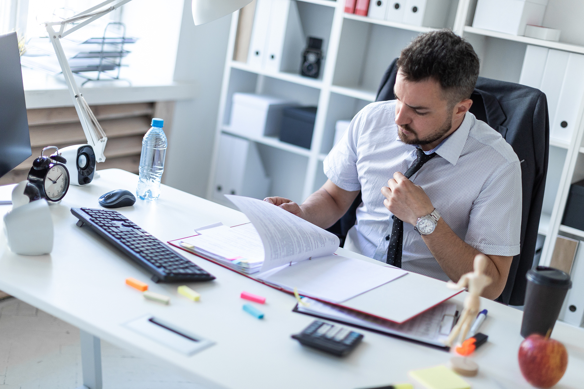 a man is sitting in the office and scrolls through the documents