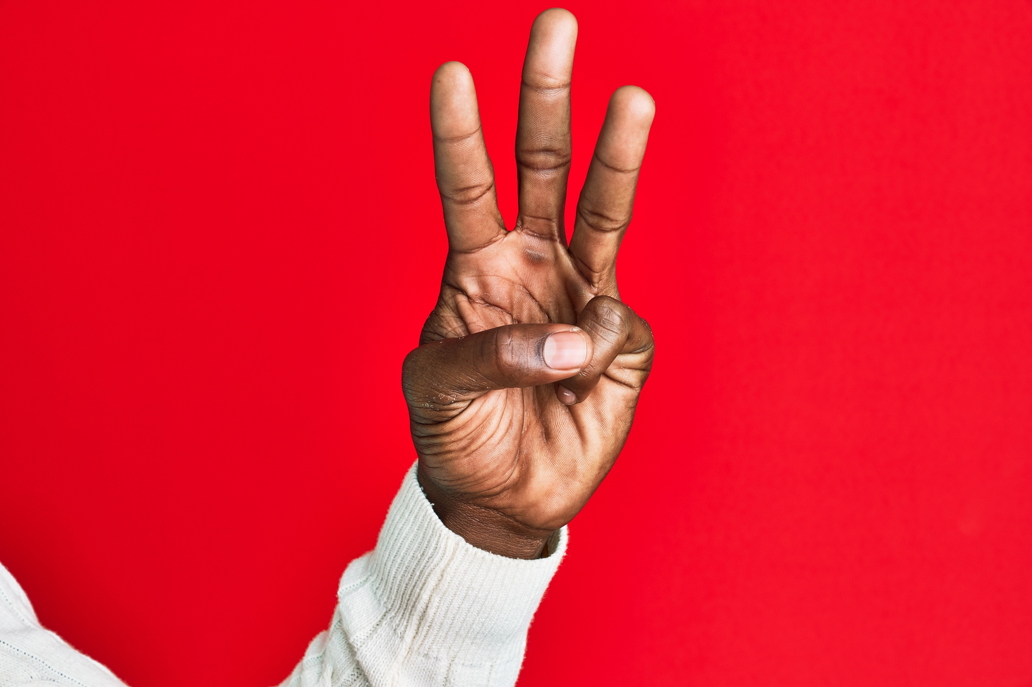 arm and hand of african american black young man over red isolat