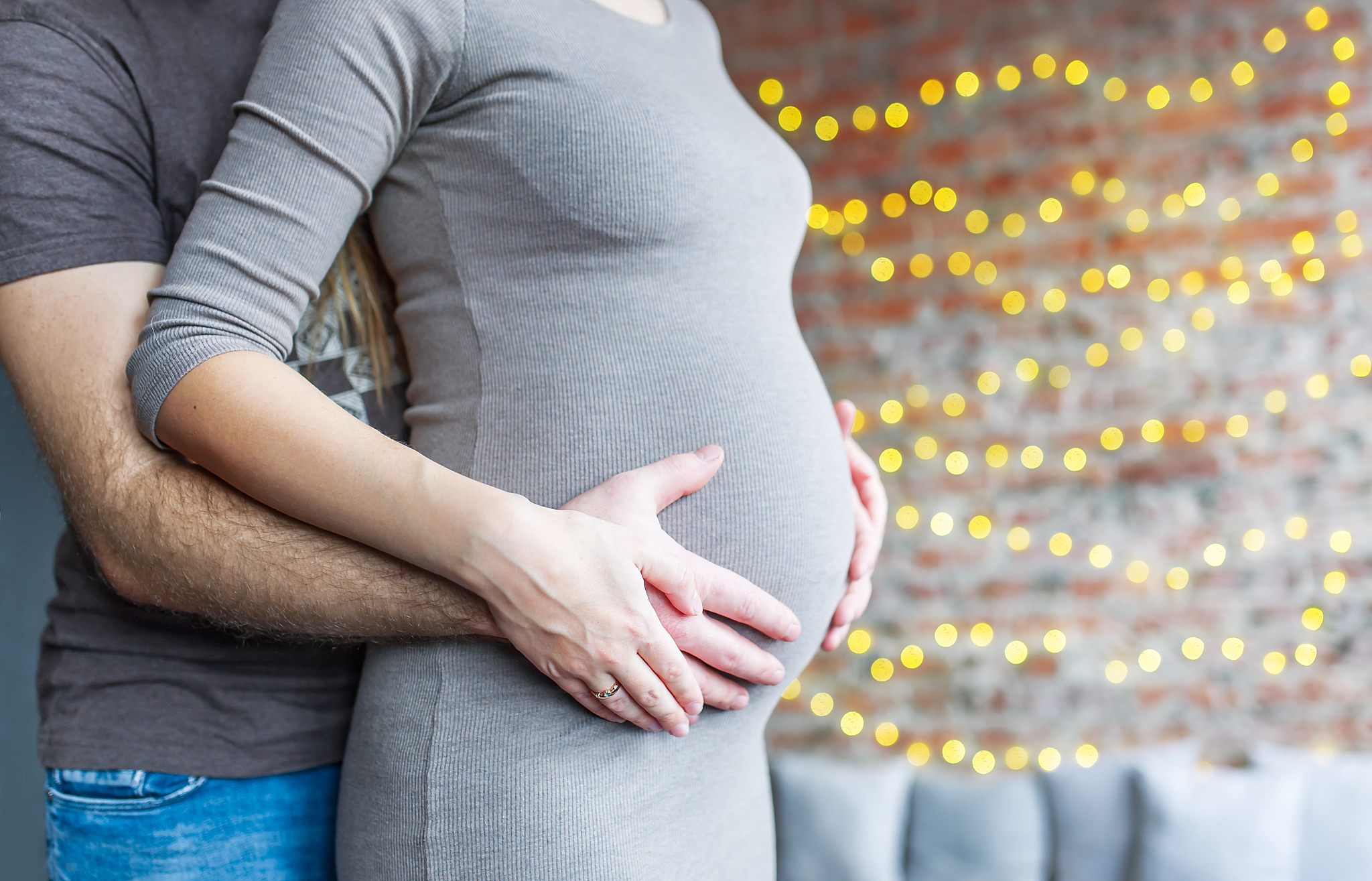 mom and dad with hands on the baby