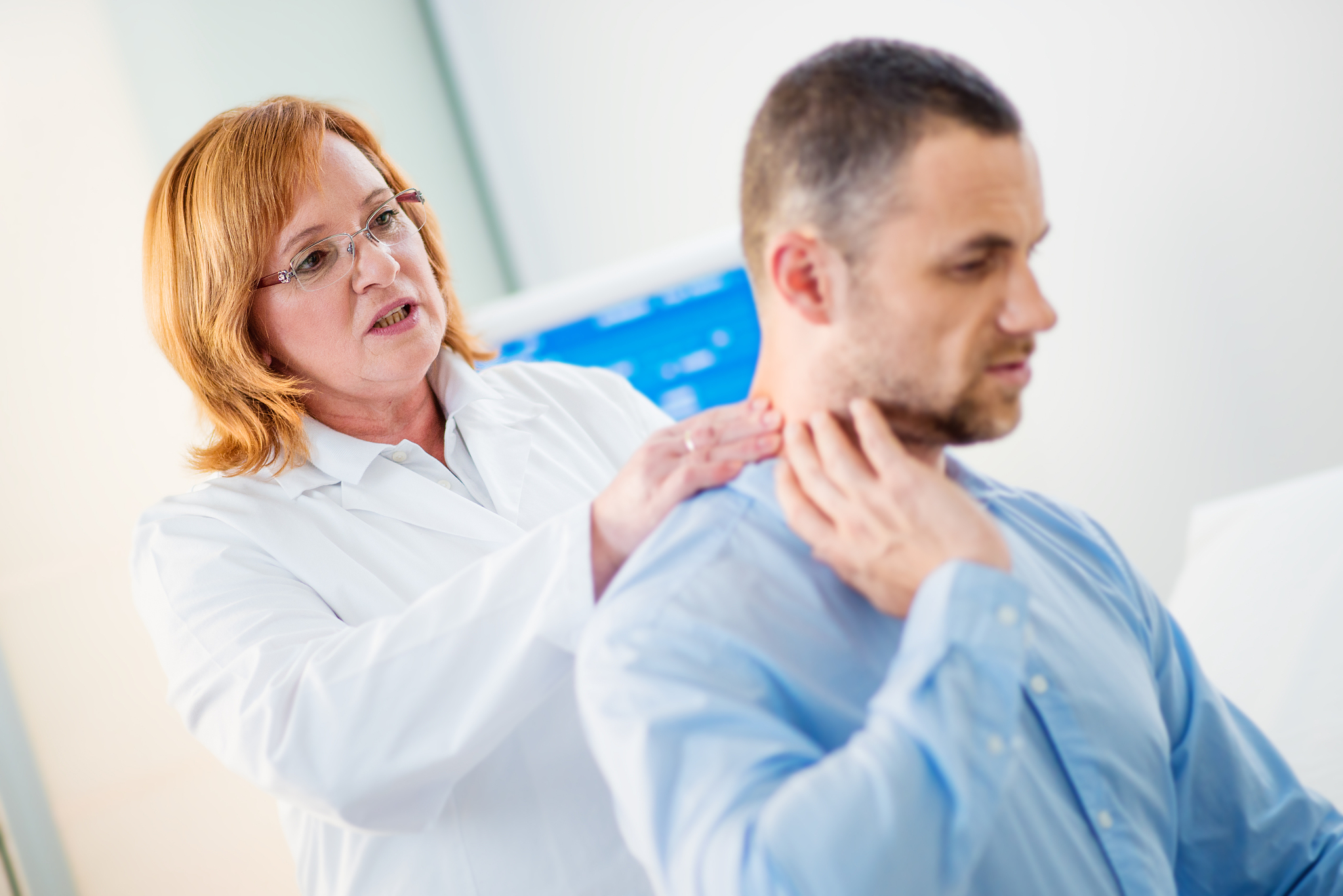 female physical therapist examines the patient's neck