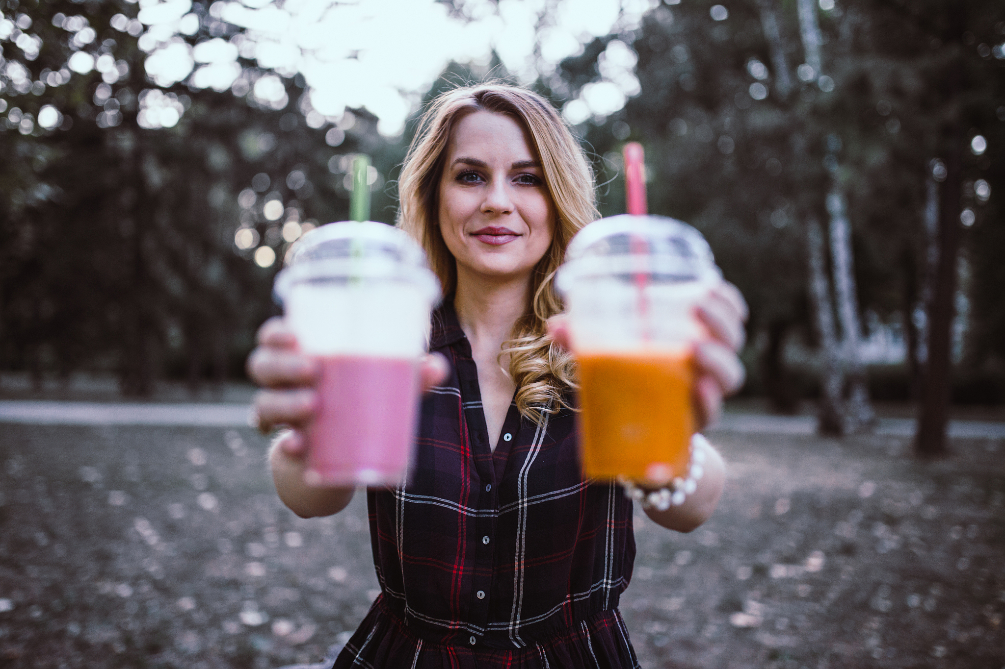 beautiful woman drinking smoothie in the public park