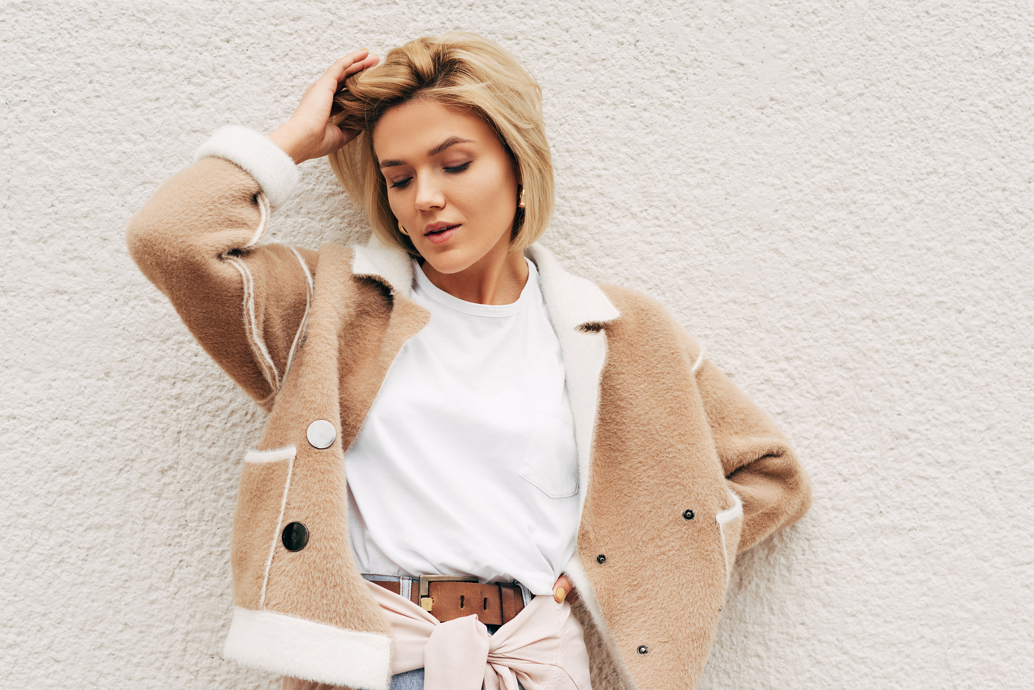 stylish blonde young woman wearing white t-shirt and beige jacke