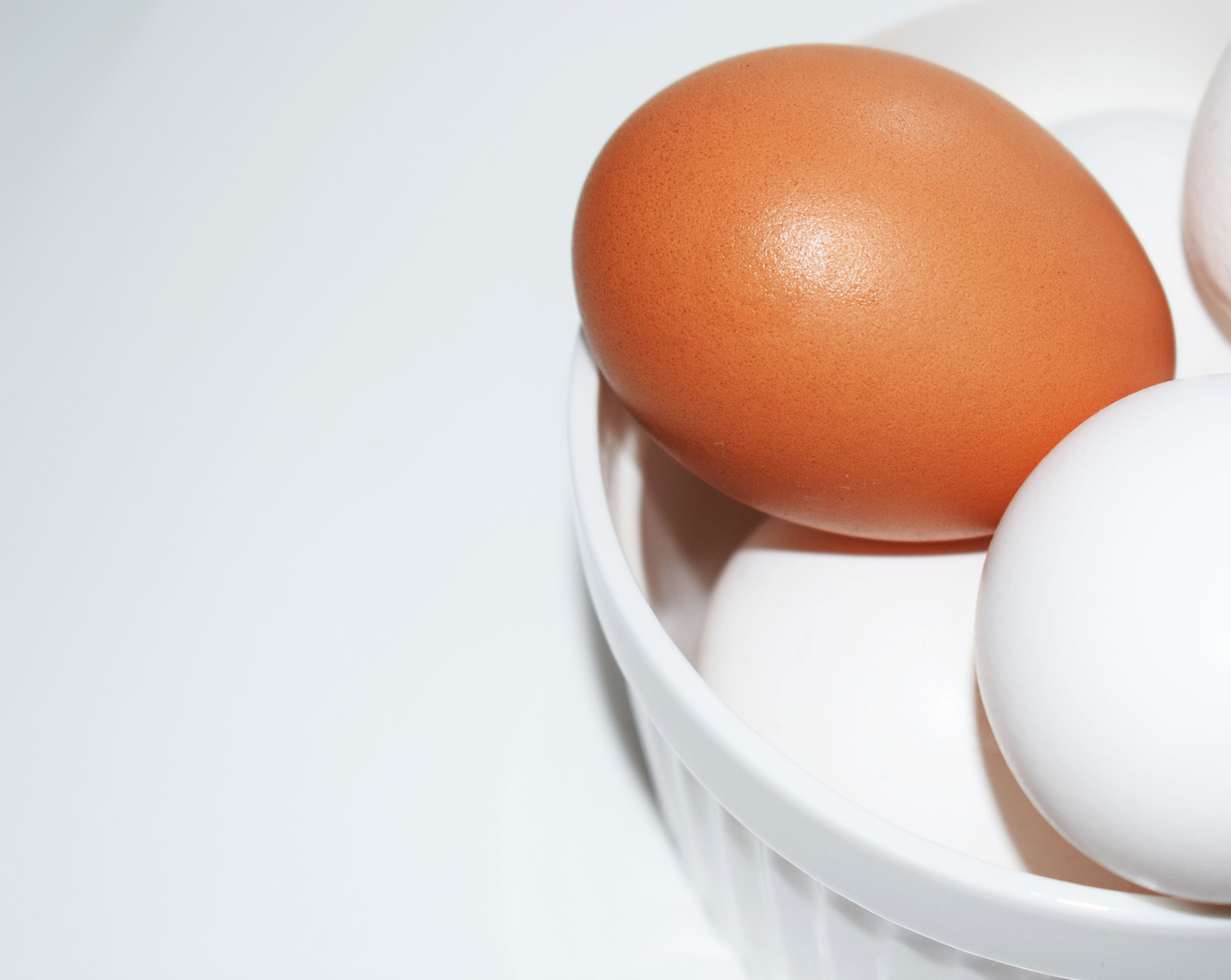 white chicken egg on white background. lots of eggs. preparation