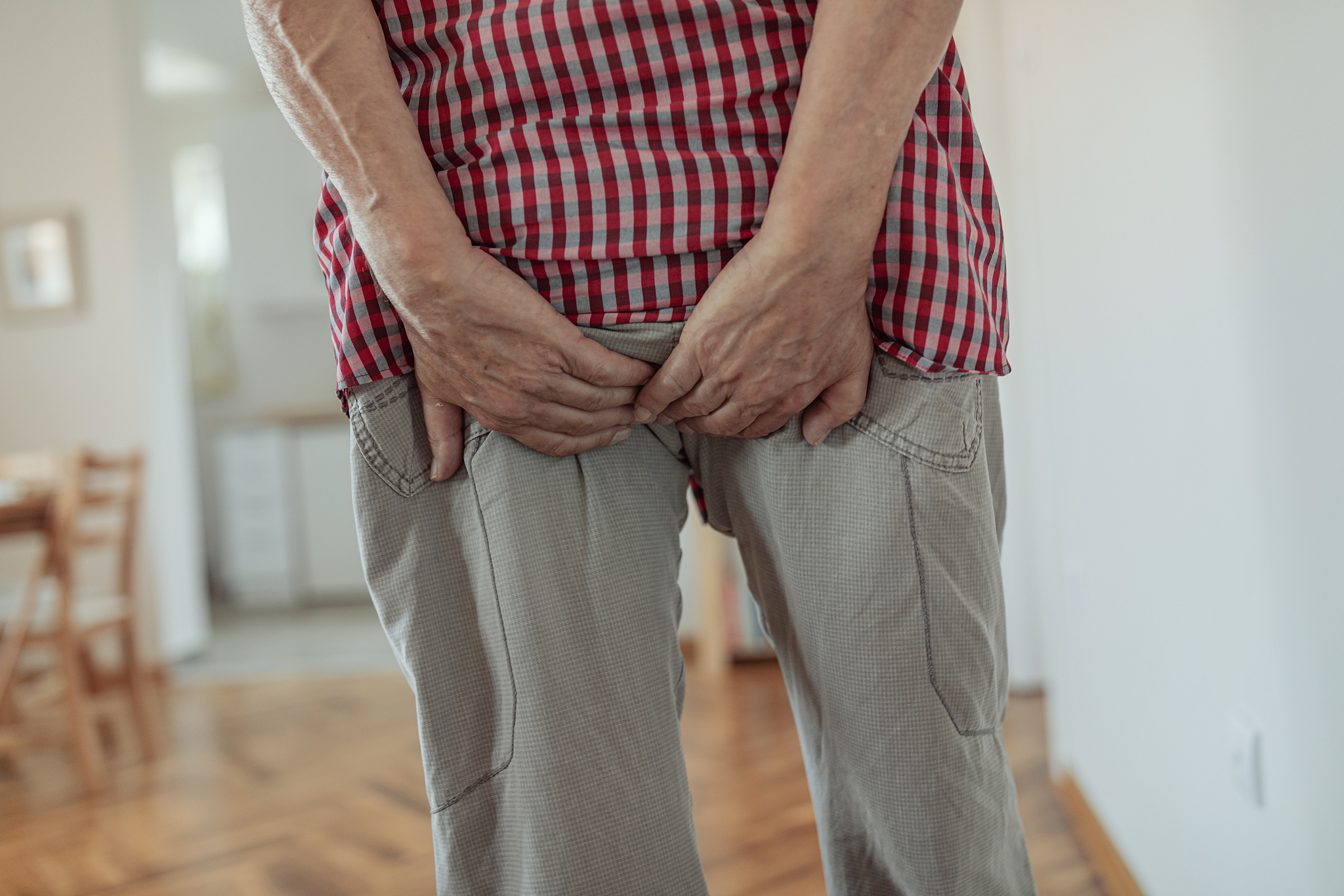 man with hemorrhoids holding his ass in pain