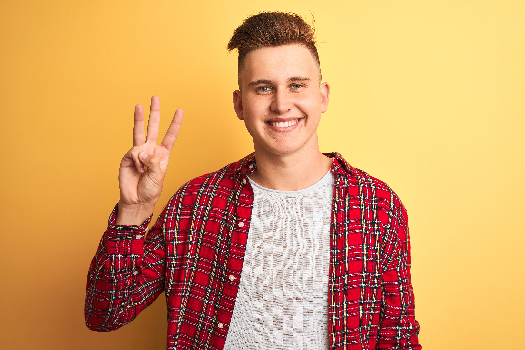 young handsome man wearing casual shirt standing over isolated y