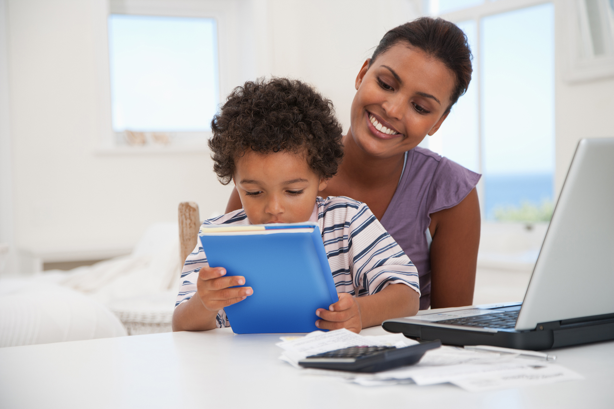 mother and son with book and laptop
