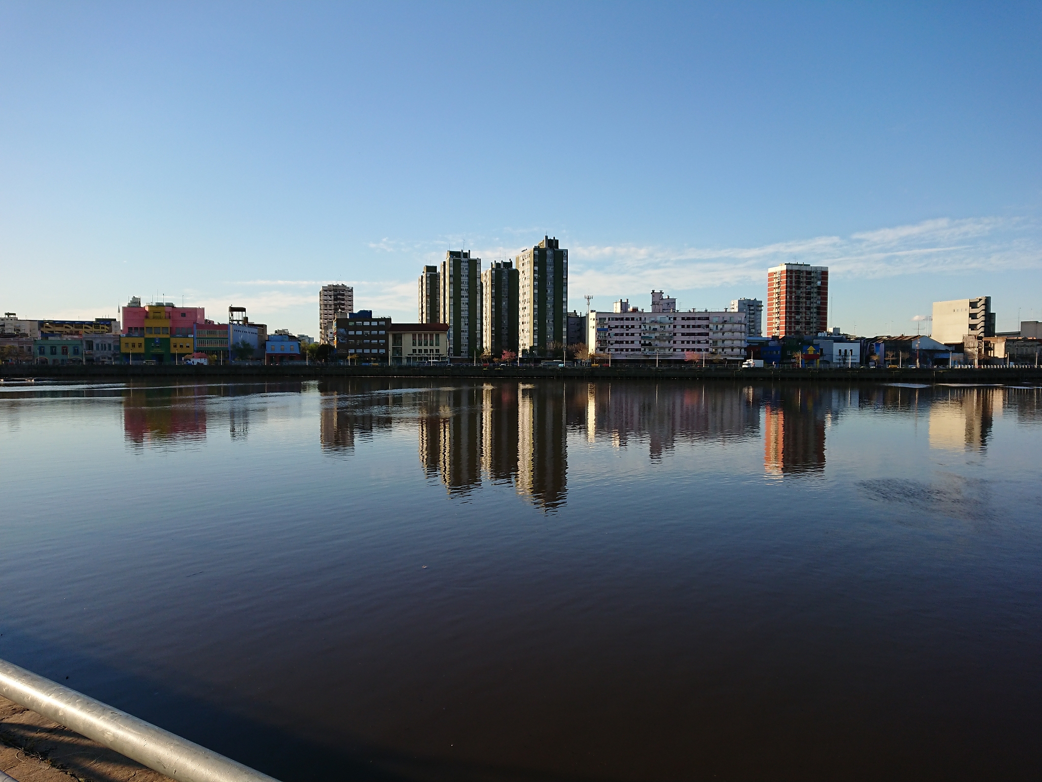 buildings by river against sky in city
