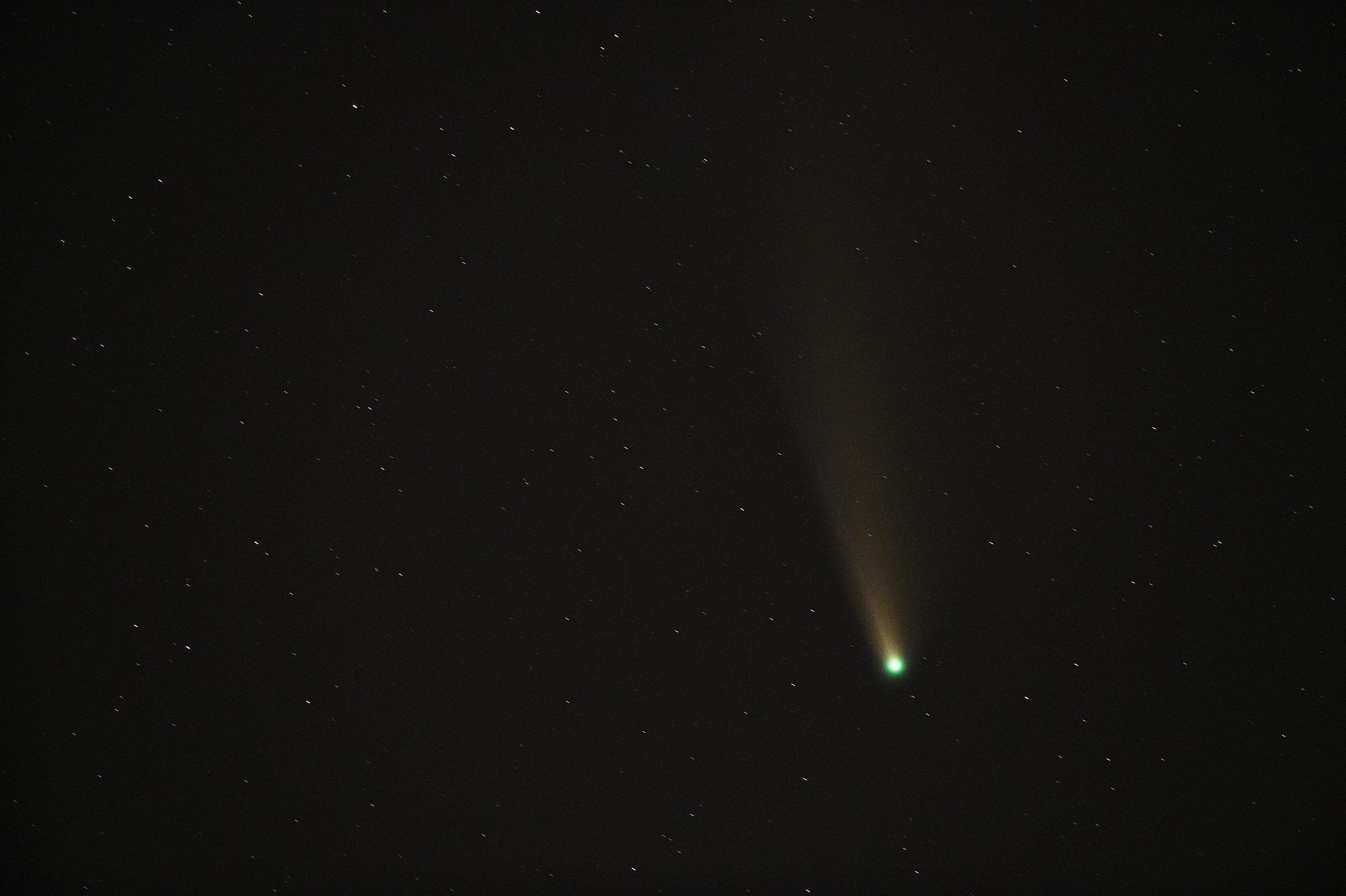 comet in the dark night sky with stars in the background