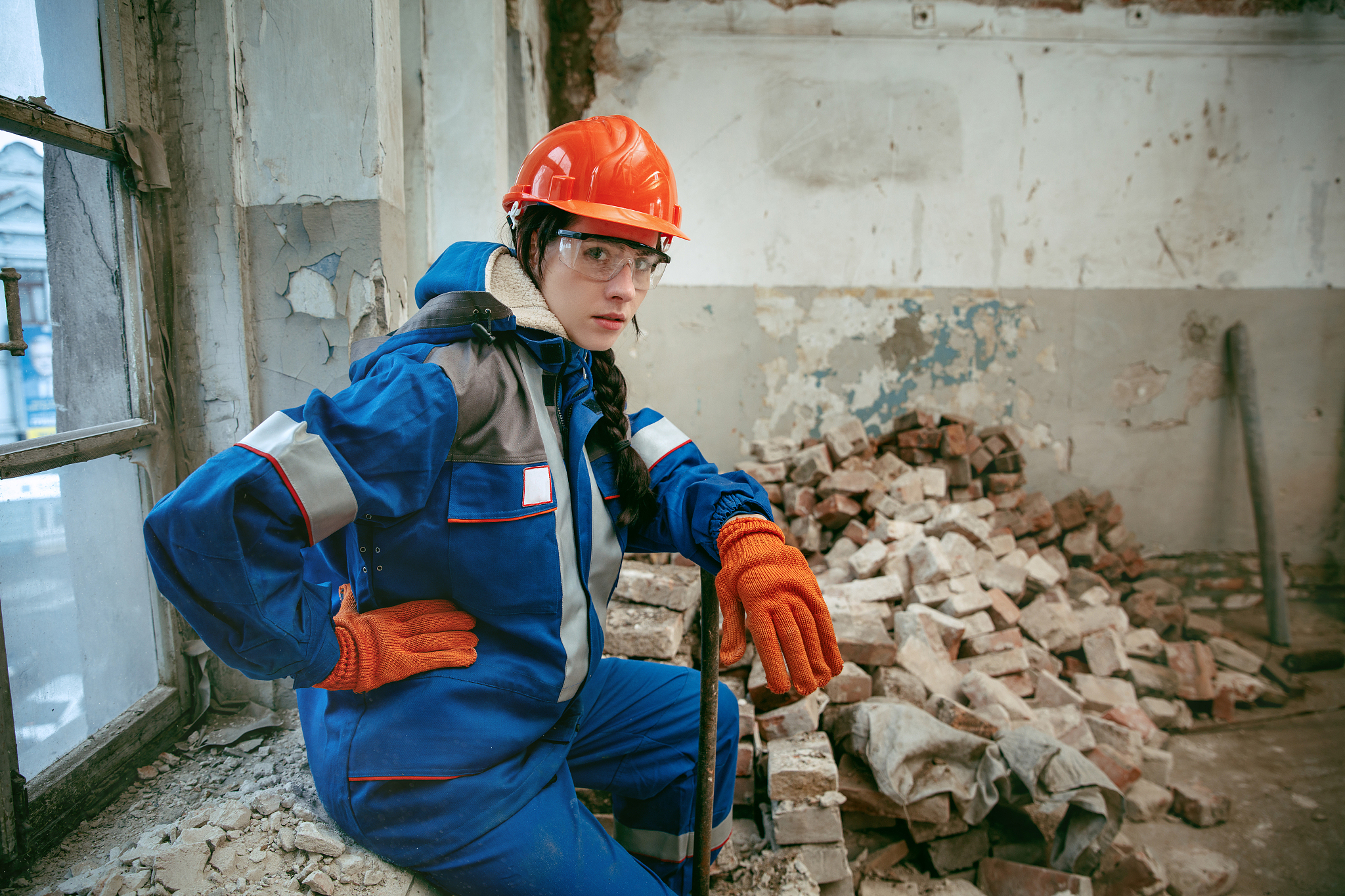 woman wearing helmet using male work tools