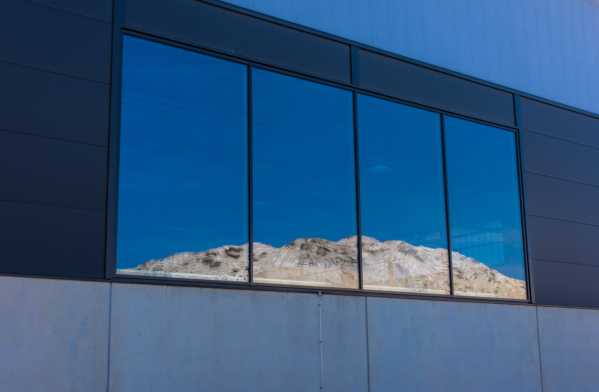 low angle view of glass building against blue sky