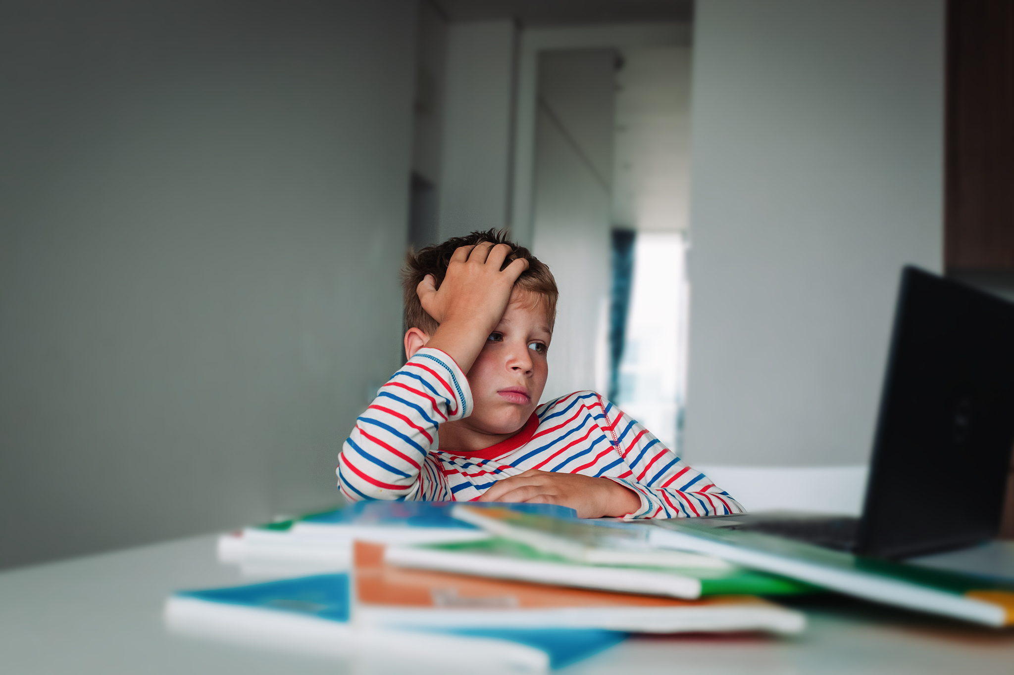 bored and sad kid looking at computer, problems with online lear