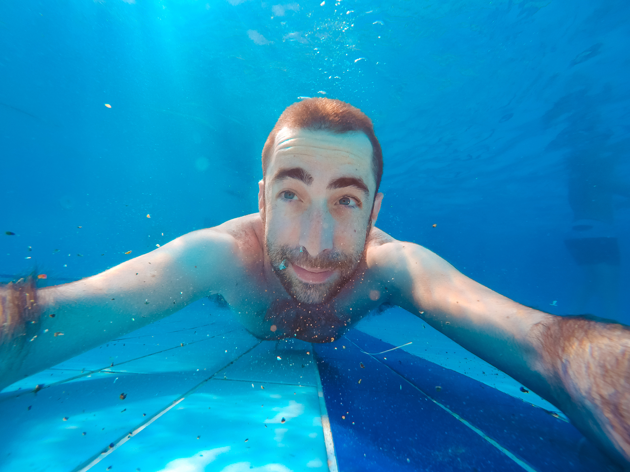 young handsome man diving underwater in a swimming pool