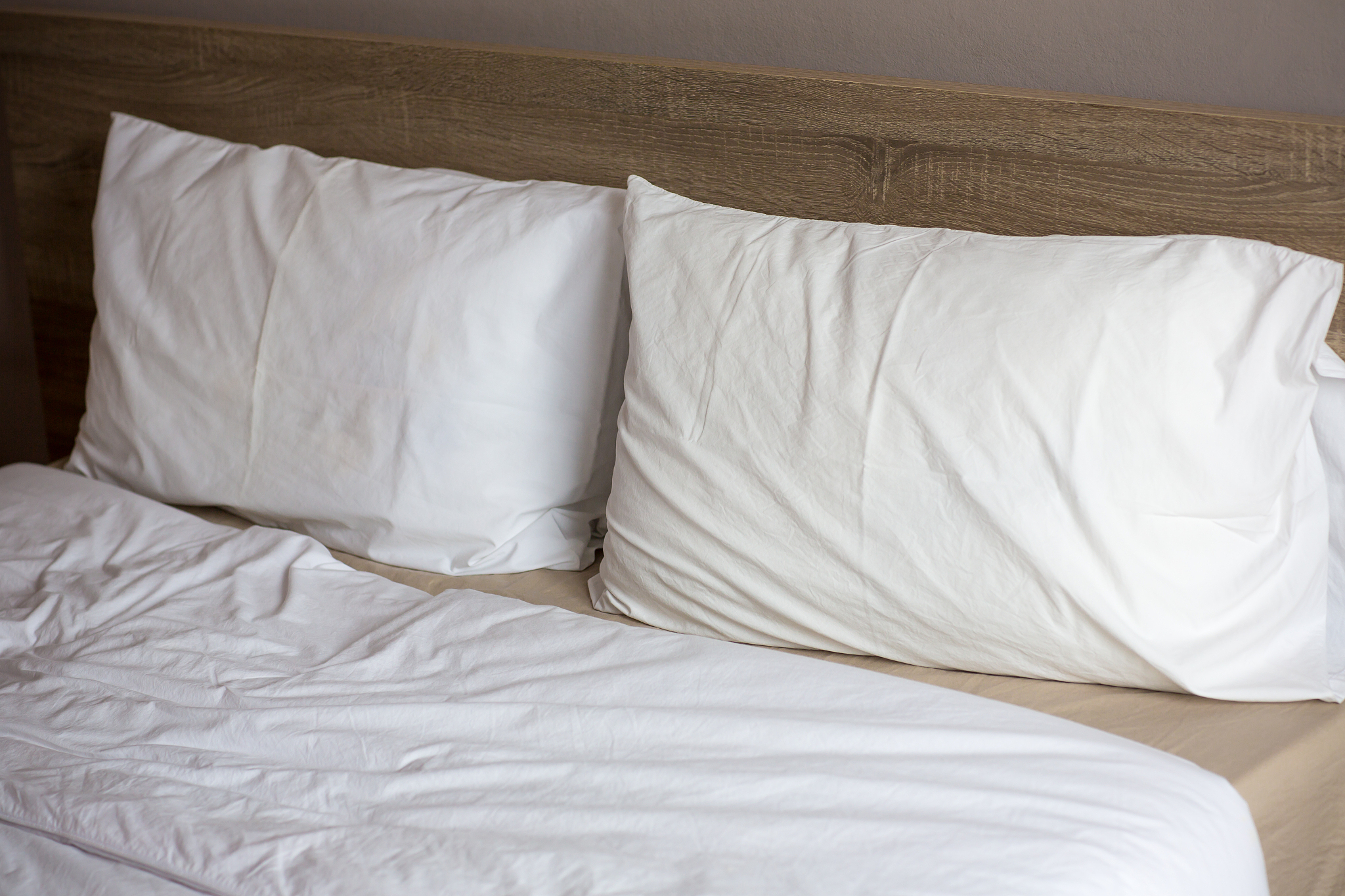 two pillows on the bed.messy bed with morning light. just wake u