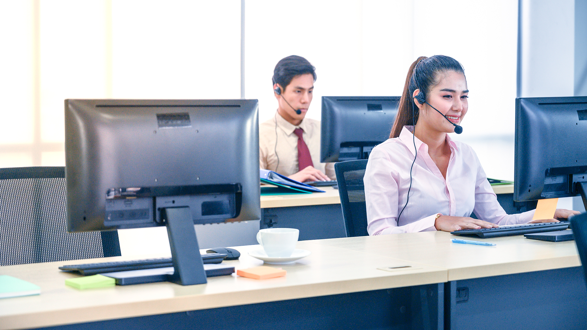 young customer service women agent with headsets and computer wo