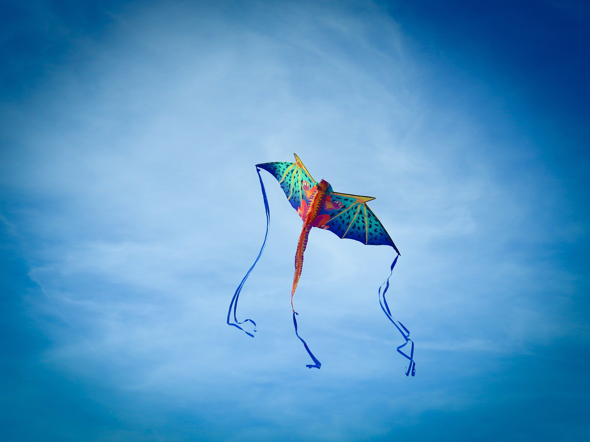 low angle view of kite flying against blue sky