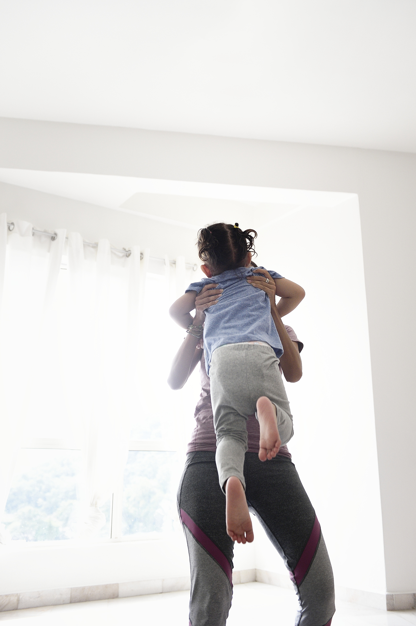 malay woman carrying a young girl at home