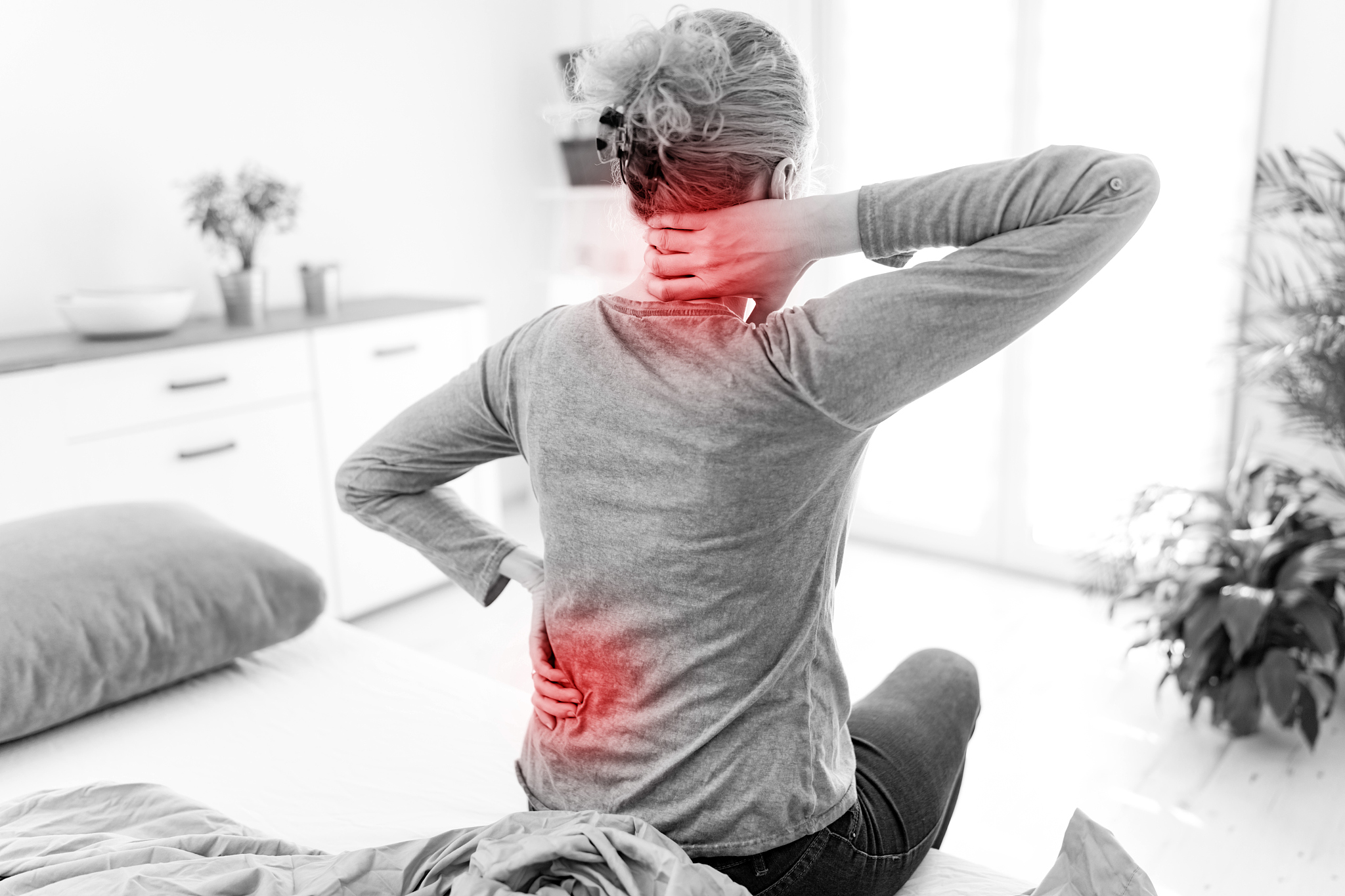 woman waking up on the bed, morning stretching, pain in the back