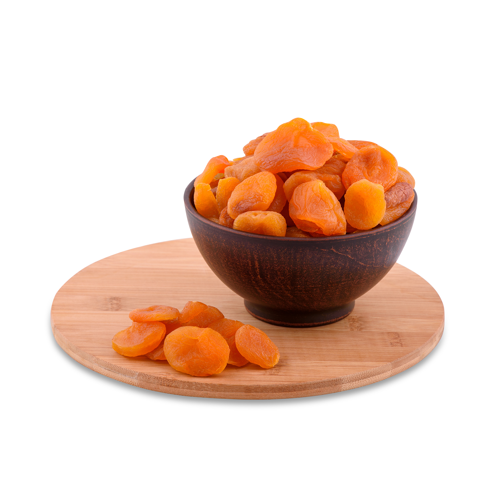 dried apricots in brown bowl on wood board isolated on white bac