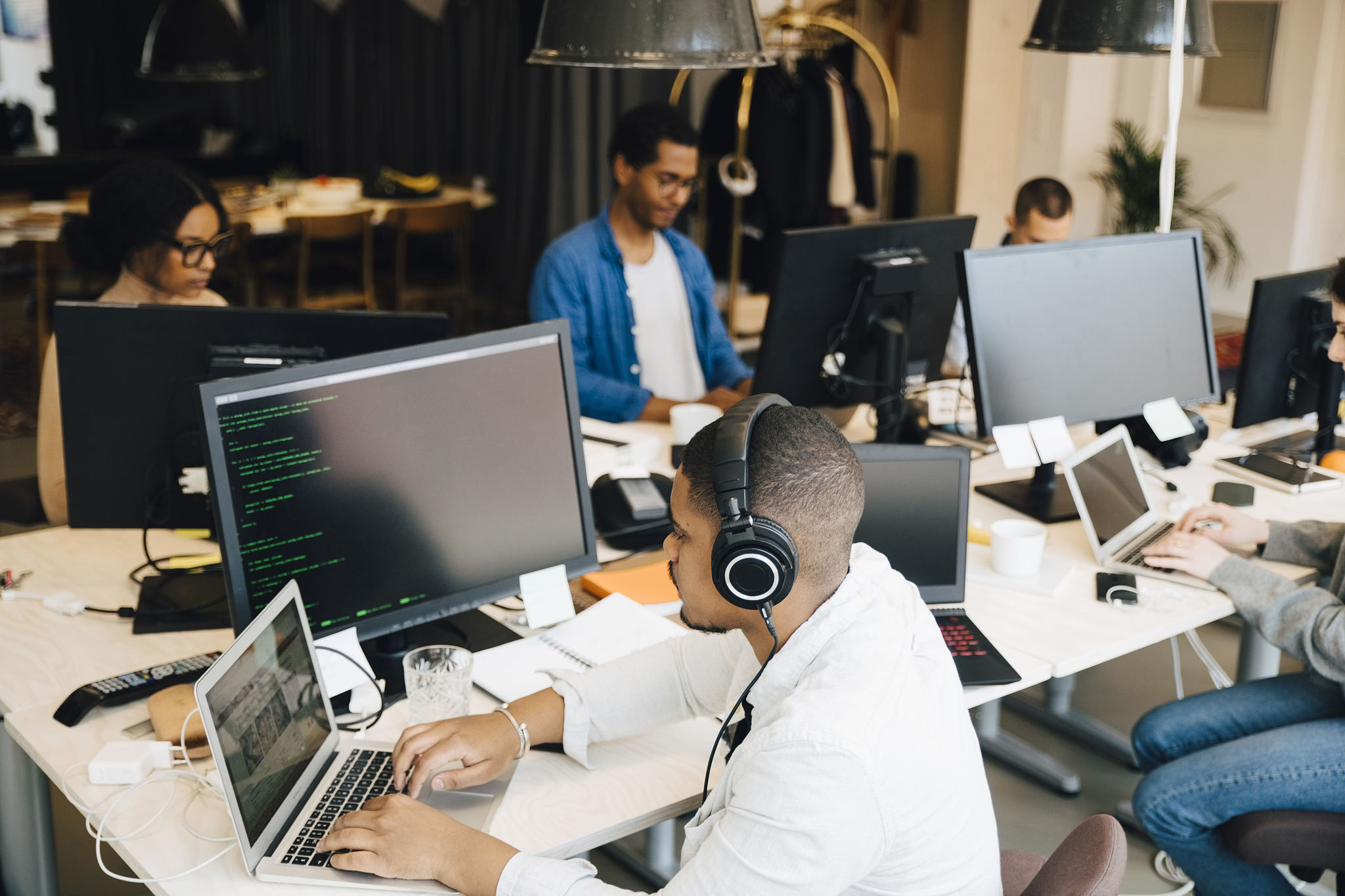 high angle view of businessman with headphones coding over lapto