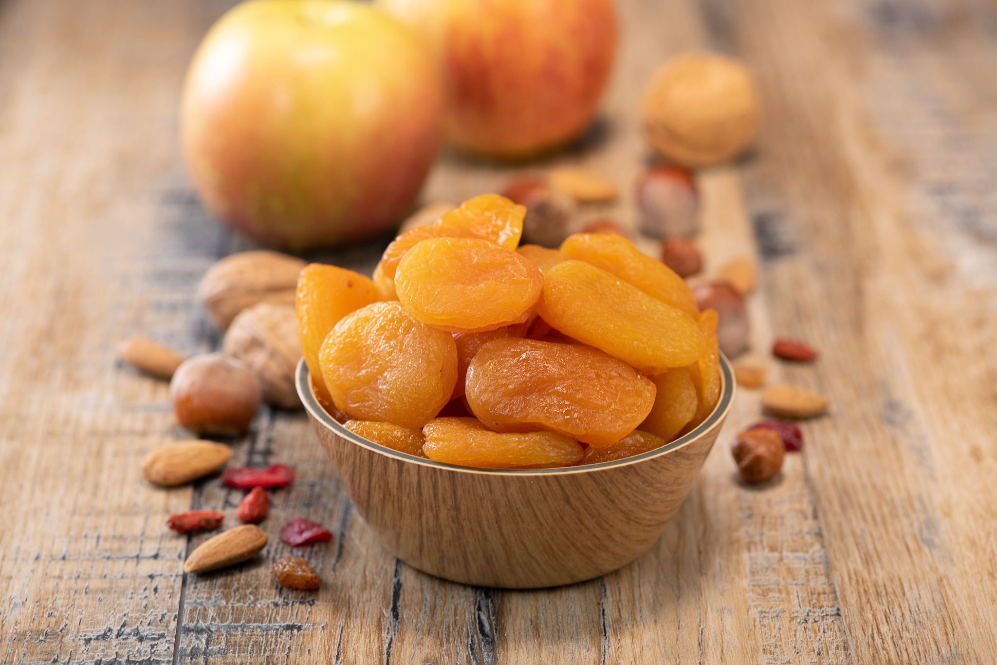 apricots, dried fruit and apple composition on wood background