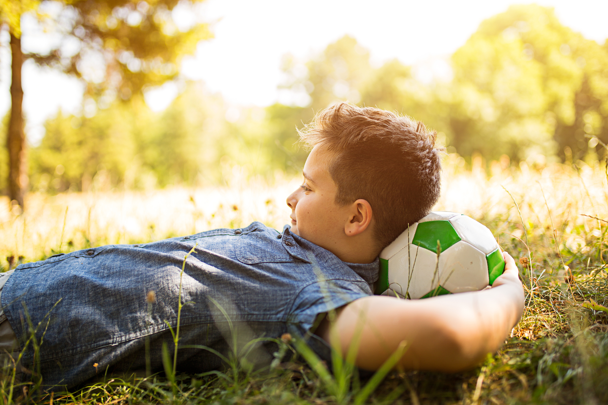 happy boy with headphones listening to music in park