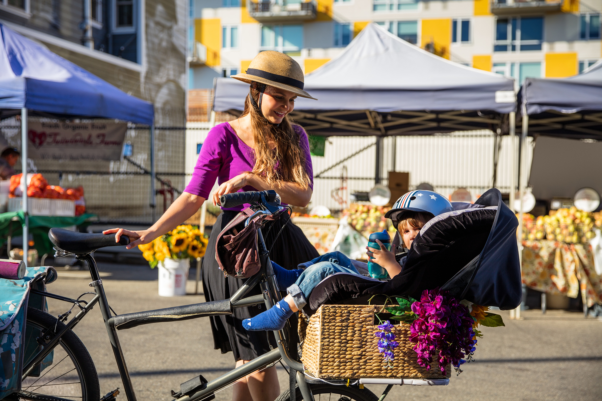 laughing woman shopping with toddler at farmer's market