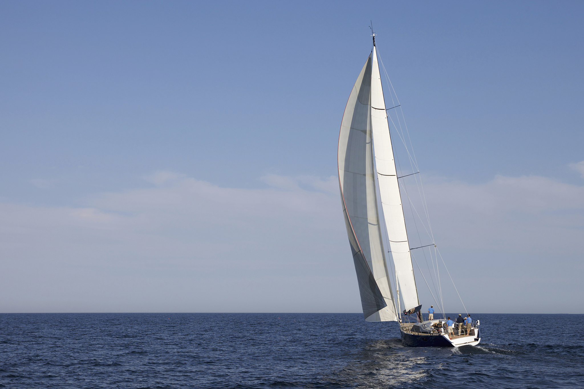 a crew races a modern ocean-going sailing yacht.