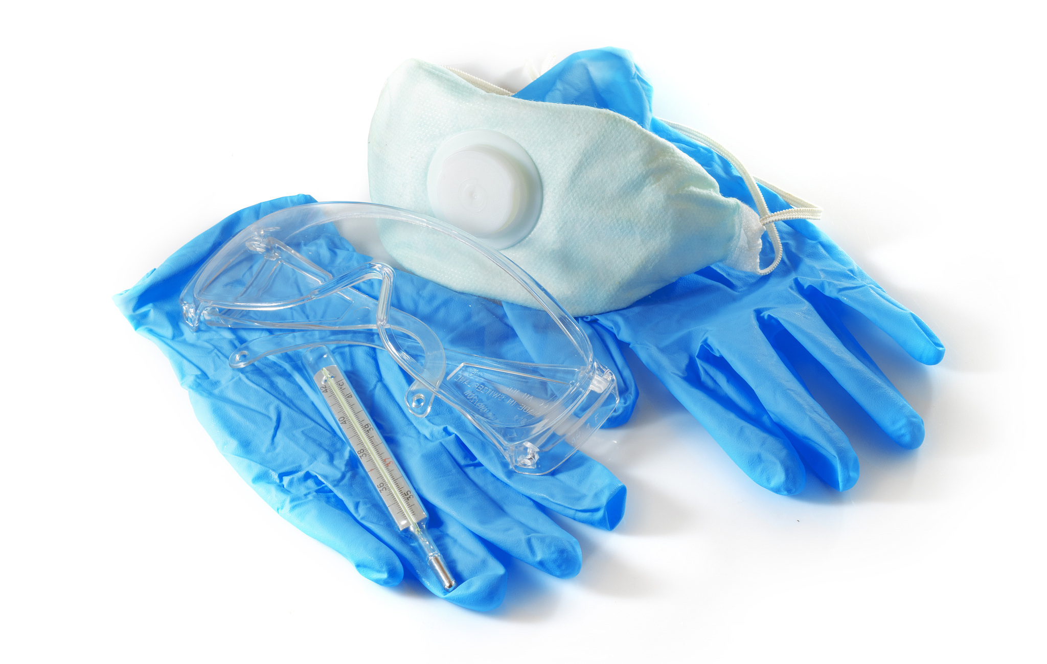 medical mask, thermometer and safety glasses on a white backgrou