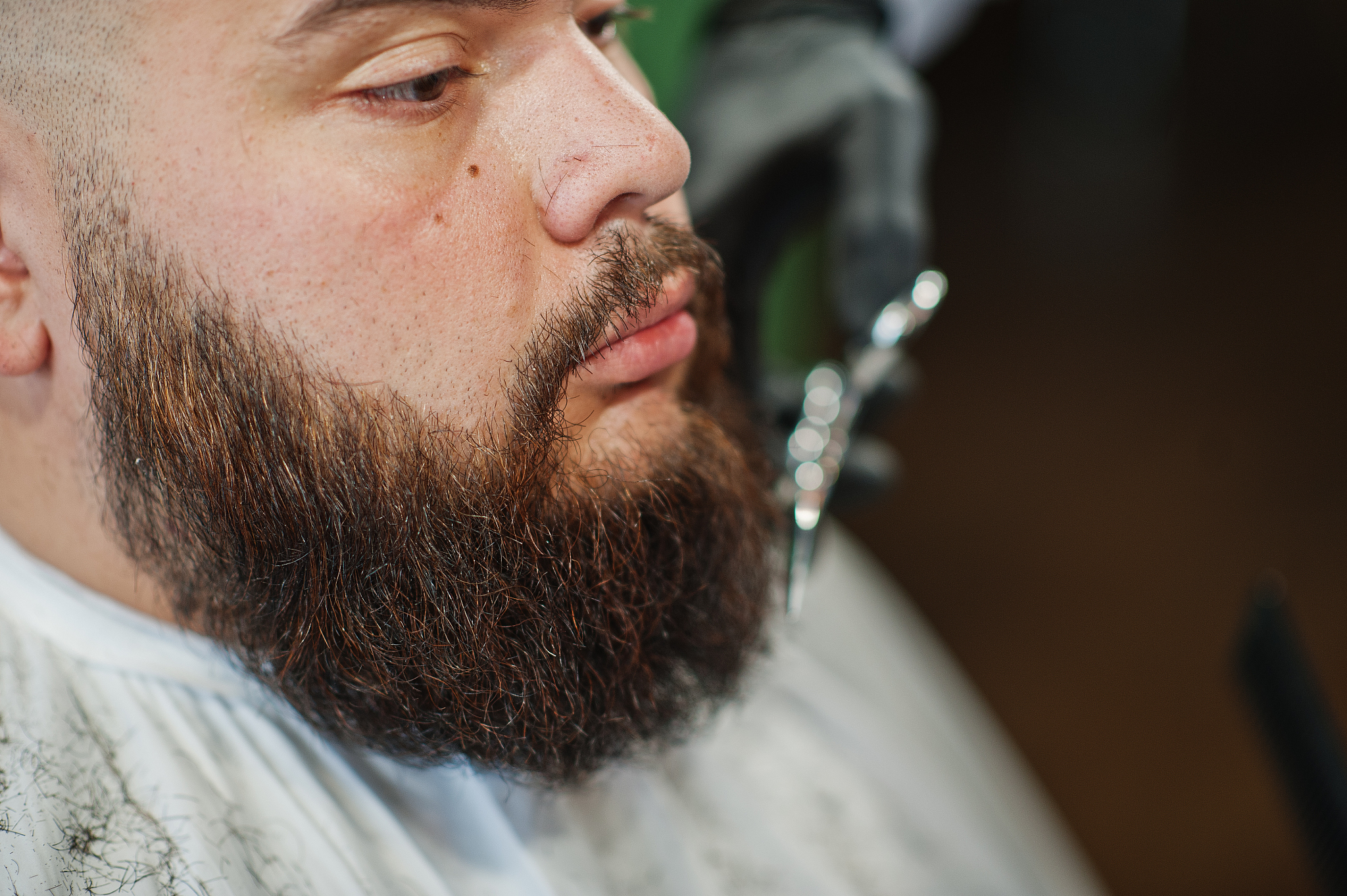 handsome bearded man at the barbershop, barber at work.
